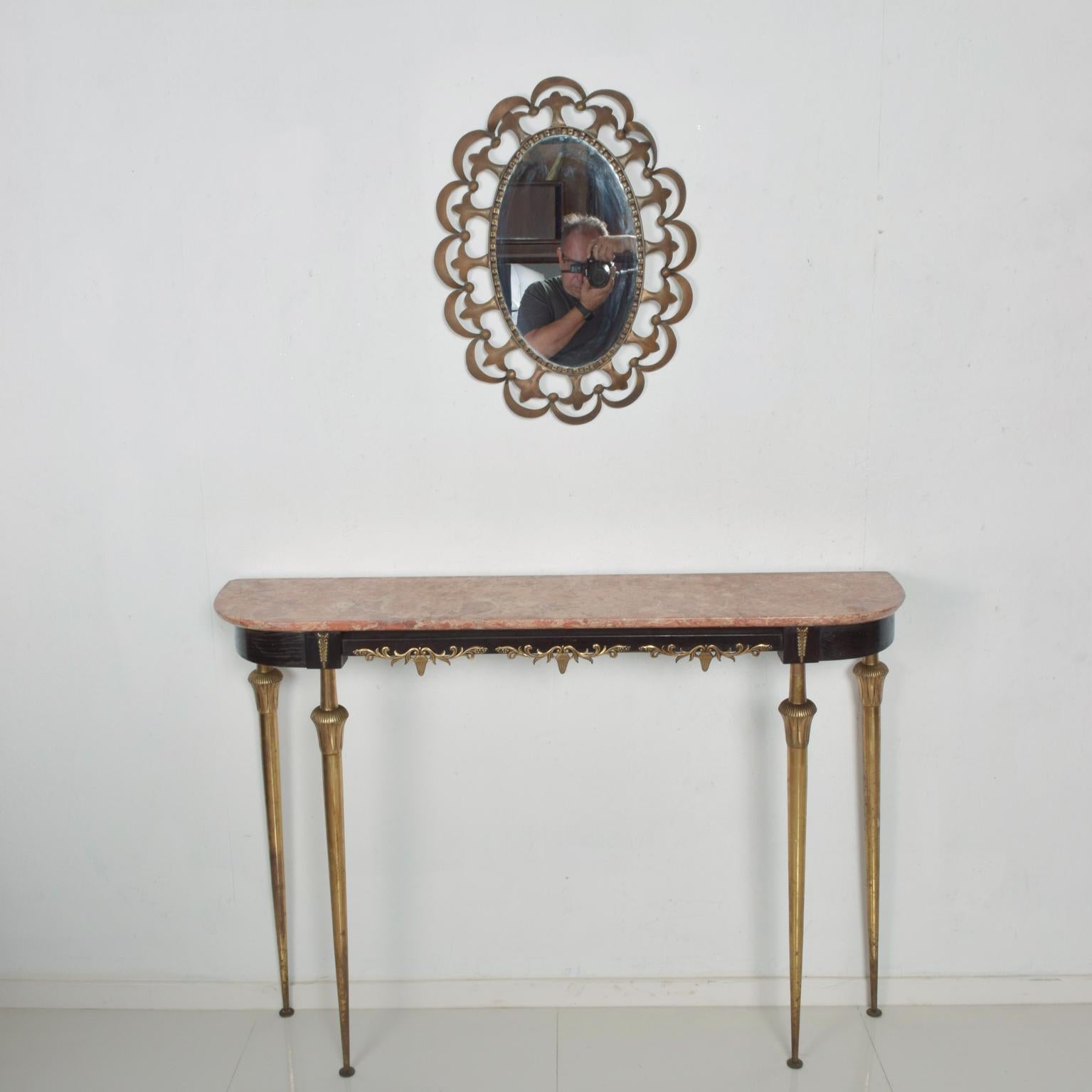 We are pleased to offer for your consideration, a beautiful console entry table, made in Italy, circa late 1940s. The table has an original top made of pink-reddish tones, which rest in top on a sculptural wood frame painted in black with bronze