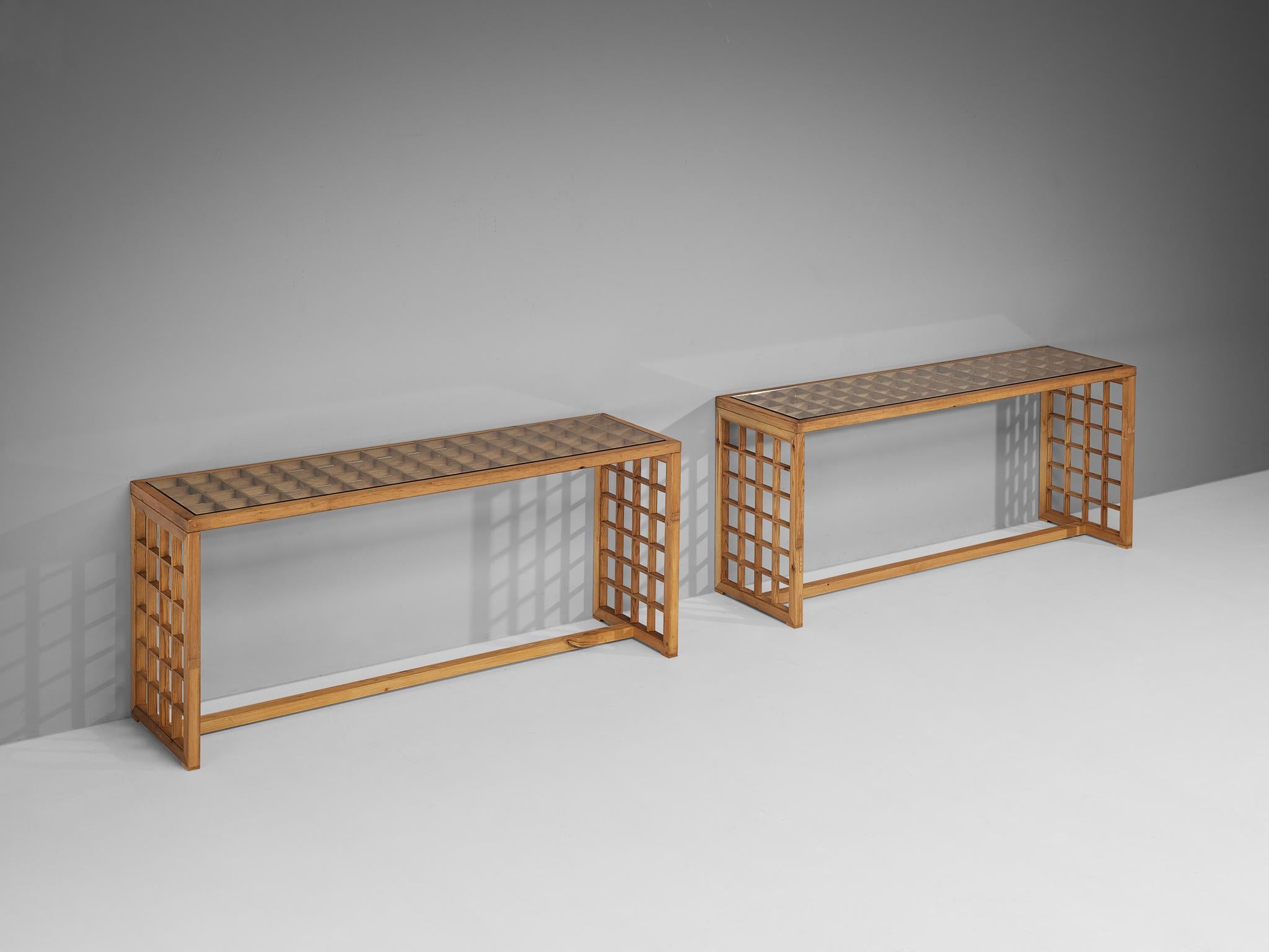 Consoles, pine, tinted glass, Italy, 1970s

Italian pair of consoles executed in a natural pine wood, made in the 1970s. The framework is characterized by an open construction with evenly spaced square openings that add a graphic and structural