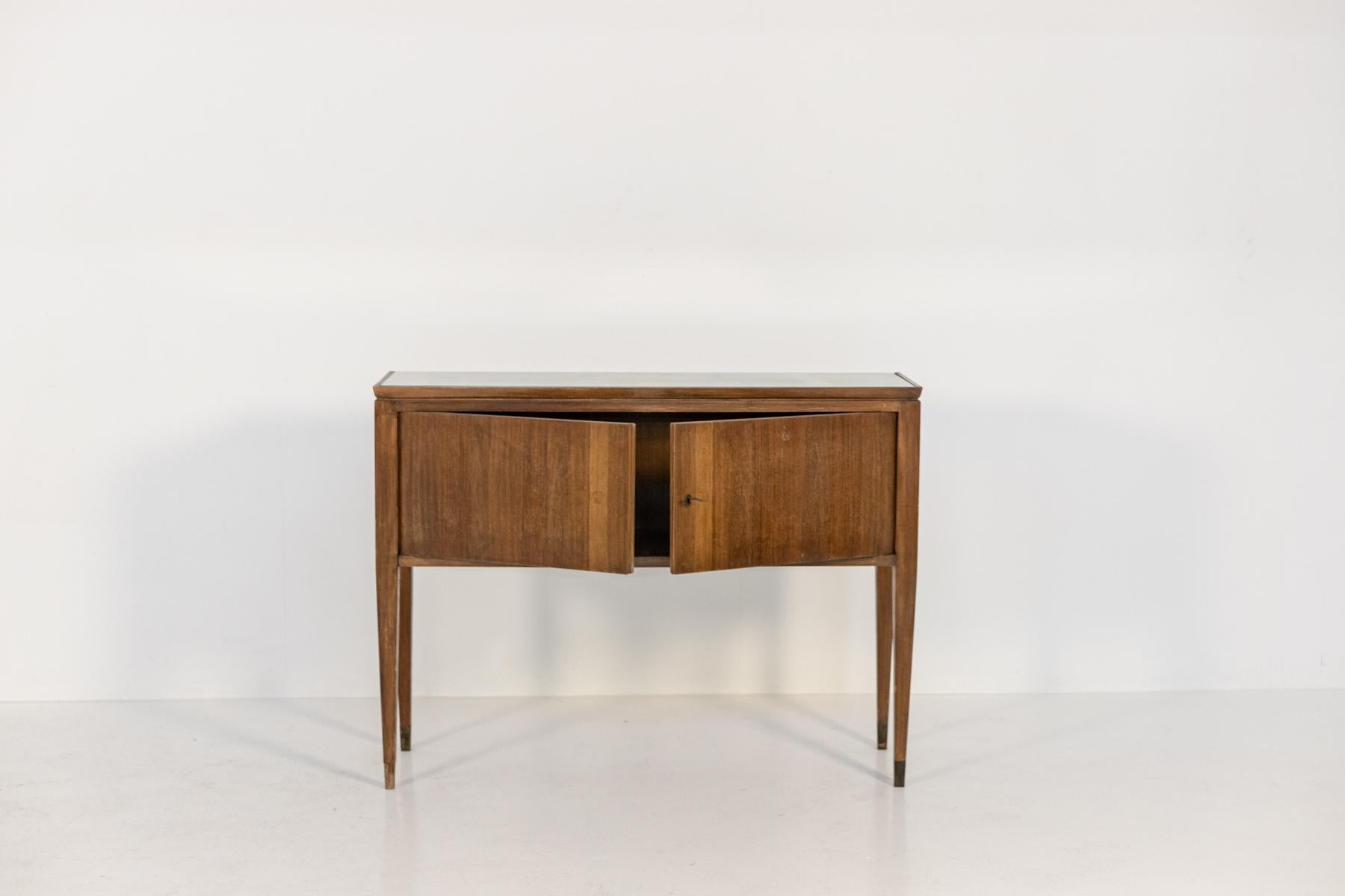 Elegant wooden console or small sideboard from the 1950's attributed to Gio Ponti.The console has a top covered with its original glass of the time still in excellent condition. Excellent Italian workmanship and original condition. The structure is