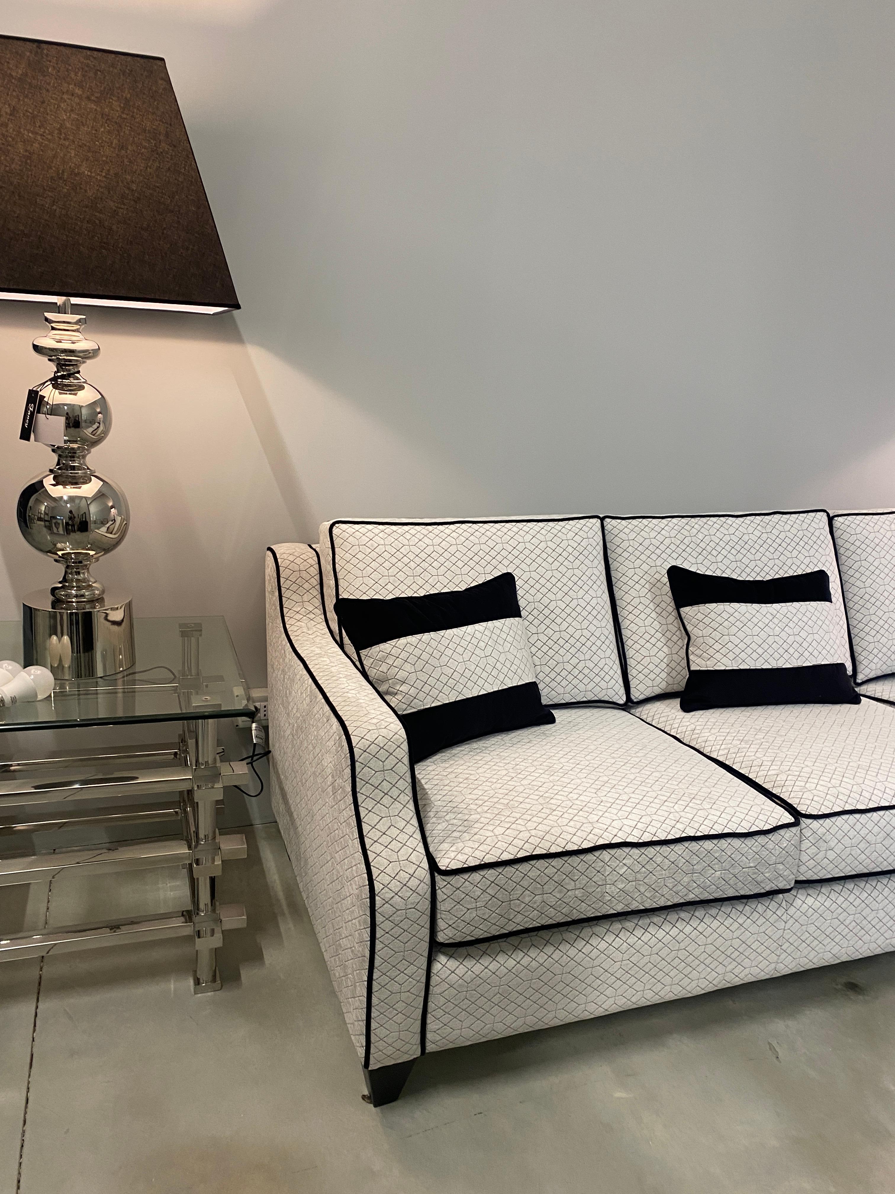 This beautiful three-seater sofa made with a handmade wooden inner structure and upholstered in a beautiful black and light grey velvet. Embellished with three back-protection cushions. The seat is divided by three large cushions and the pyramid