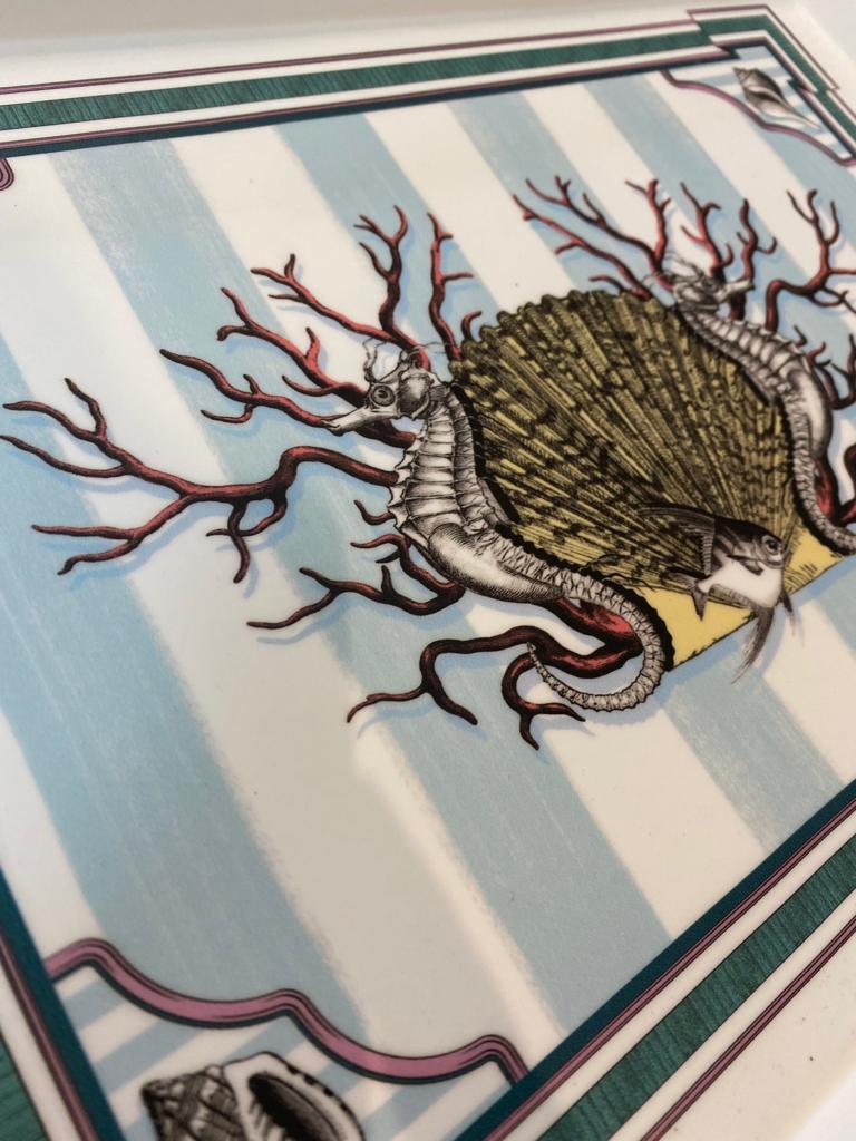 Elegant printed pocket tray with handles represents marine elements such as shells corals seahorses on a delicate blue and white striped background. The finish is matt white.

Completely produced in Florence, Italy by Artecornici design. All