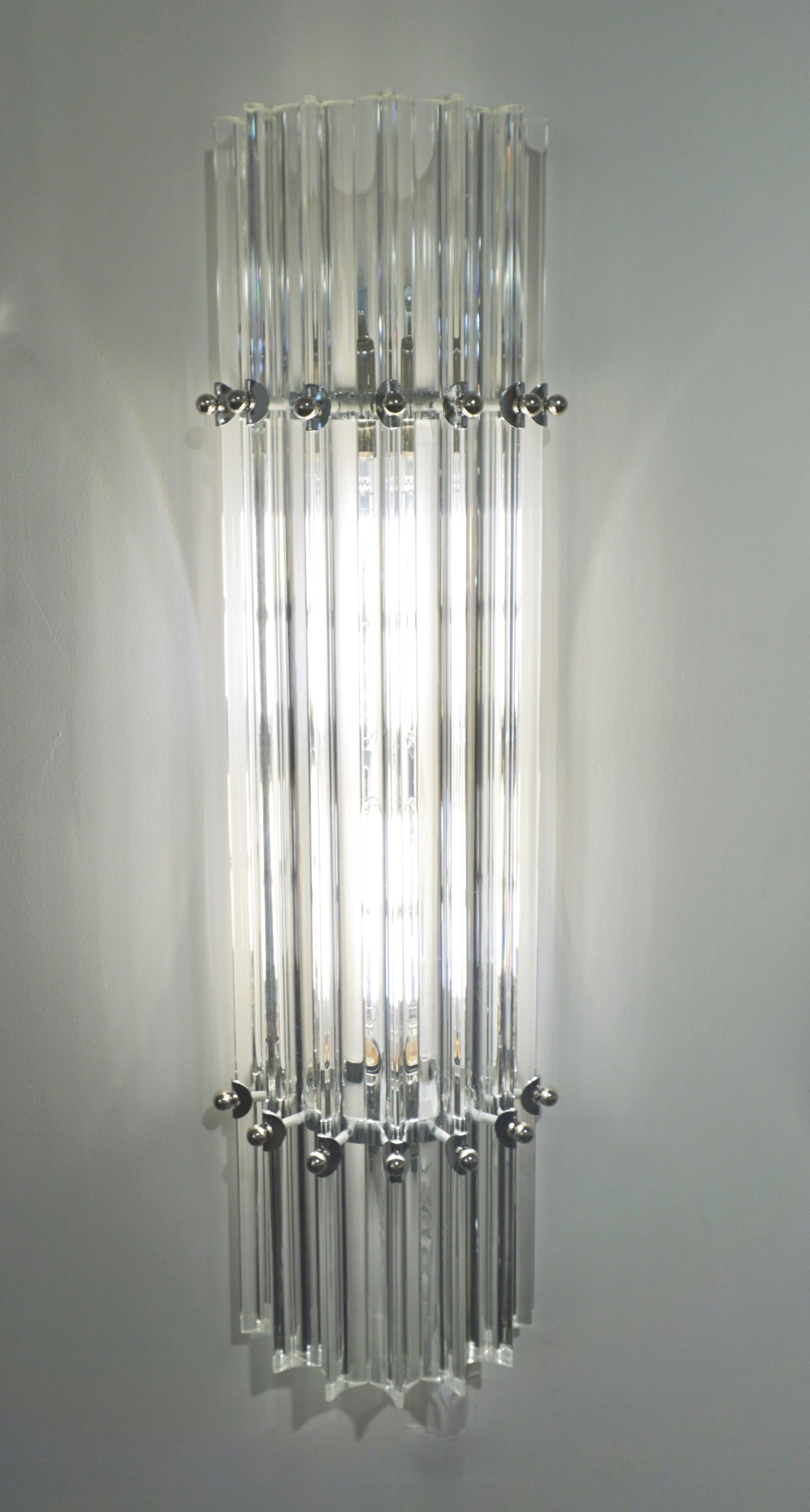 Very sleek custom Venetian sconce with organic minimalist design, consisting of seven straight crystal clear Murano glass rods of triangular section with amazing concave sides, that not only highlight the curved design but amplify the light