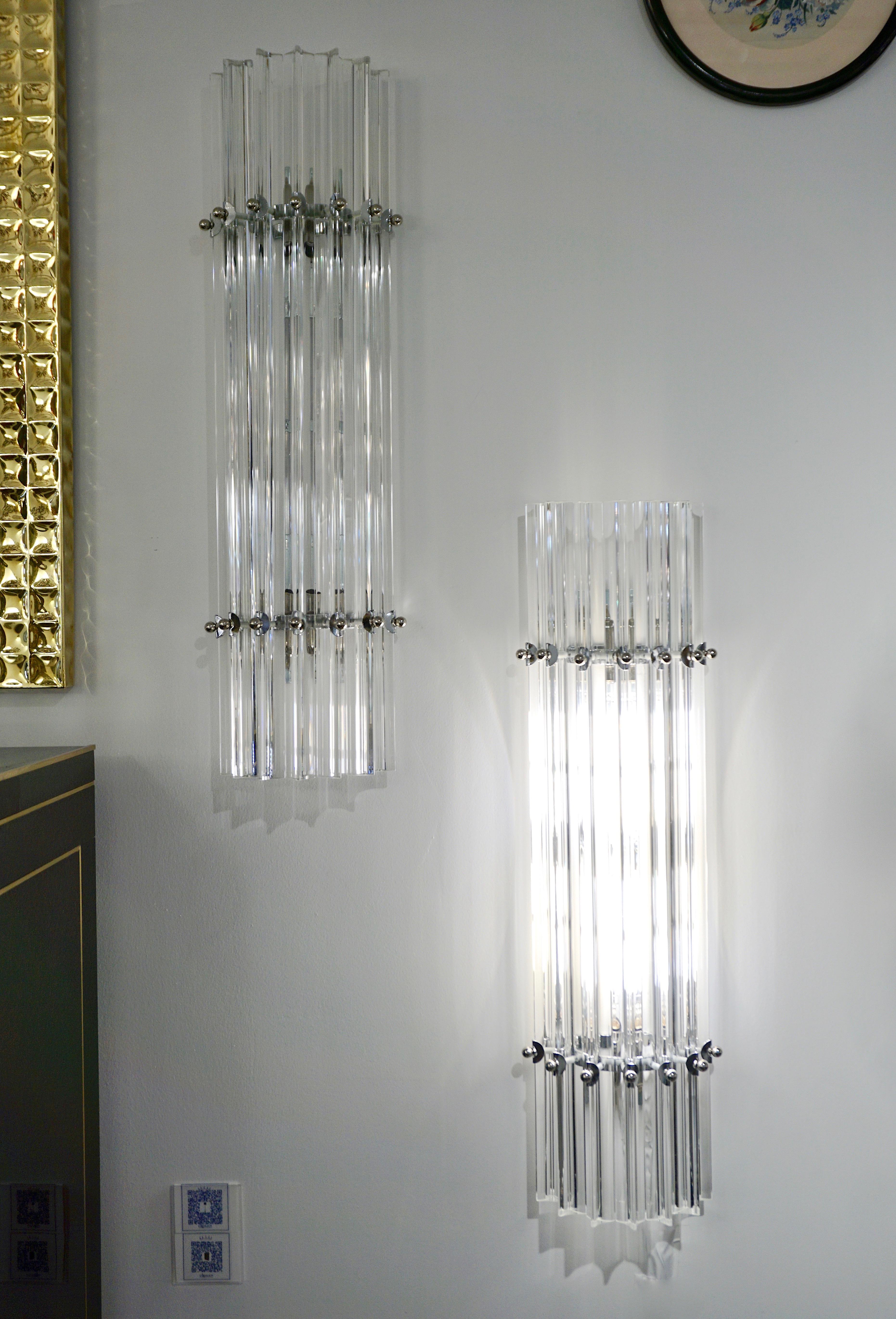 Very sleek custom Venetian pair of wall lights with organic minimalist design, consisting of seven straight crystal clear Murano glass rods of triangular section with amazing concave sides, that not only highlight the curved design but amplify the