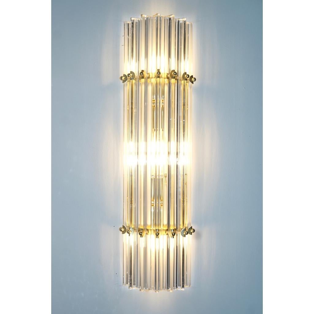 One pair available now in New York - Very sleek custom Venetian pair of crystal wall lights with organic modern design, consisting of seven straight crystal clear Murano glass rods of triangular section with attractive concave sides, that not only