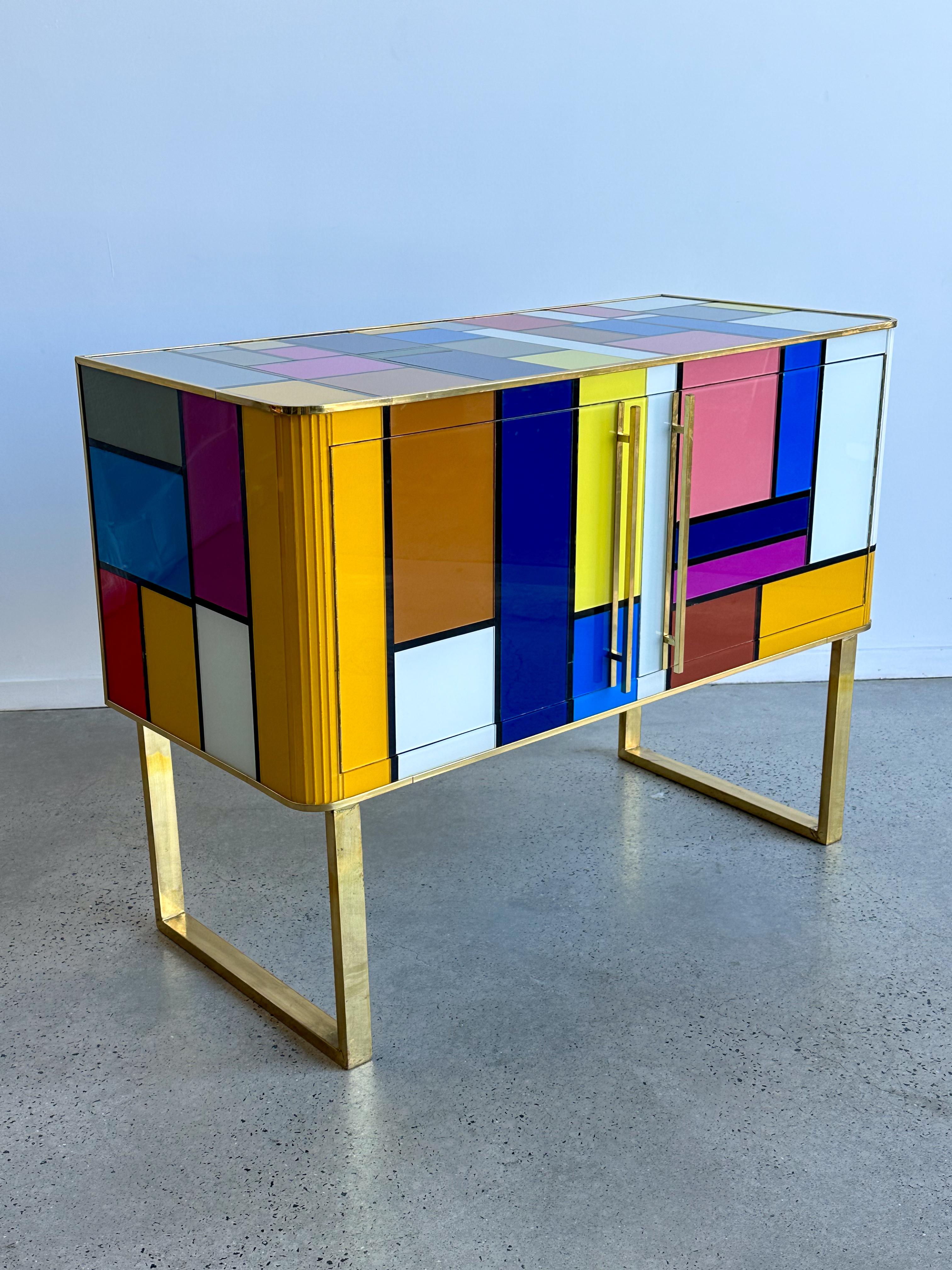 Beautiful sideboard designed by us and handcrafted in Venice with structure and interior in solid wood, legs and finishes in brass and tops and decorations in colored Murano glass. It is an object of high quality and refinement, ideal for giving