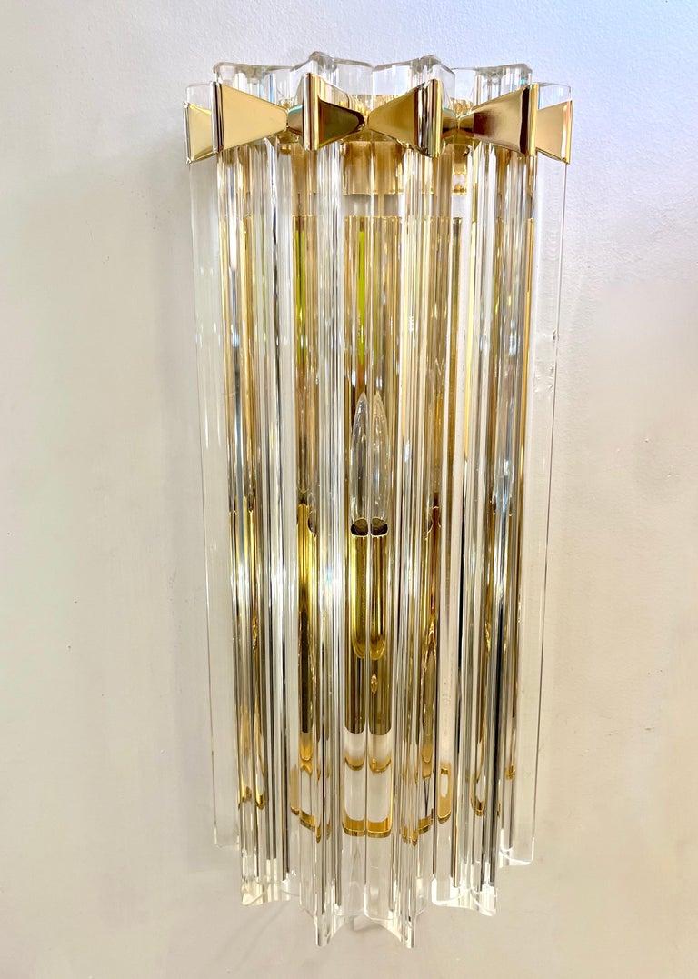 Very sleek Venetian pair of wall lights with organic Minimalist design and Art Deco flair, consisting of six spectacular straight crystal clear Murano glass rods of triangular section with stunning concave sides that amplifies the light reflections