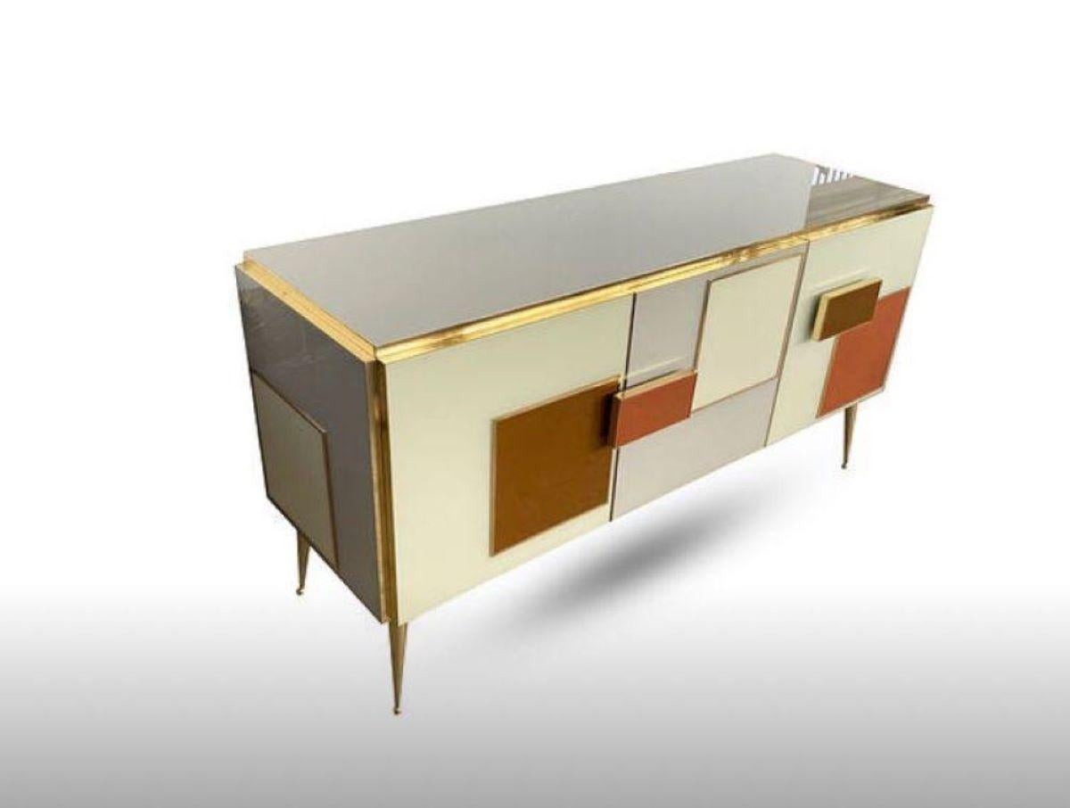 Beautiful sideboard designed and handcrafted by us with structure and interior in solid wood, legs and finishes in brass and tops and decorations in sand and brown colored Murano glass. 
It is an object of high quality and refinement, ideal for