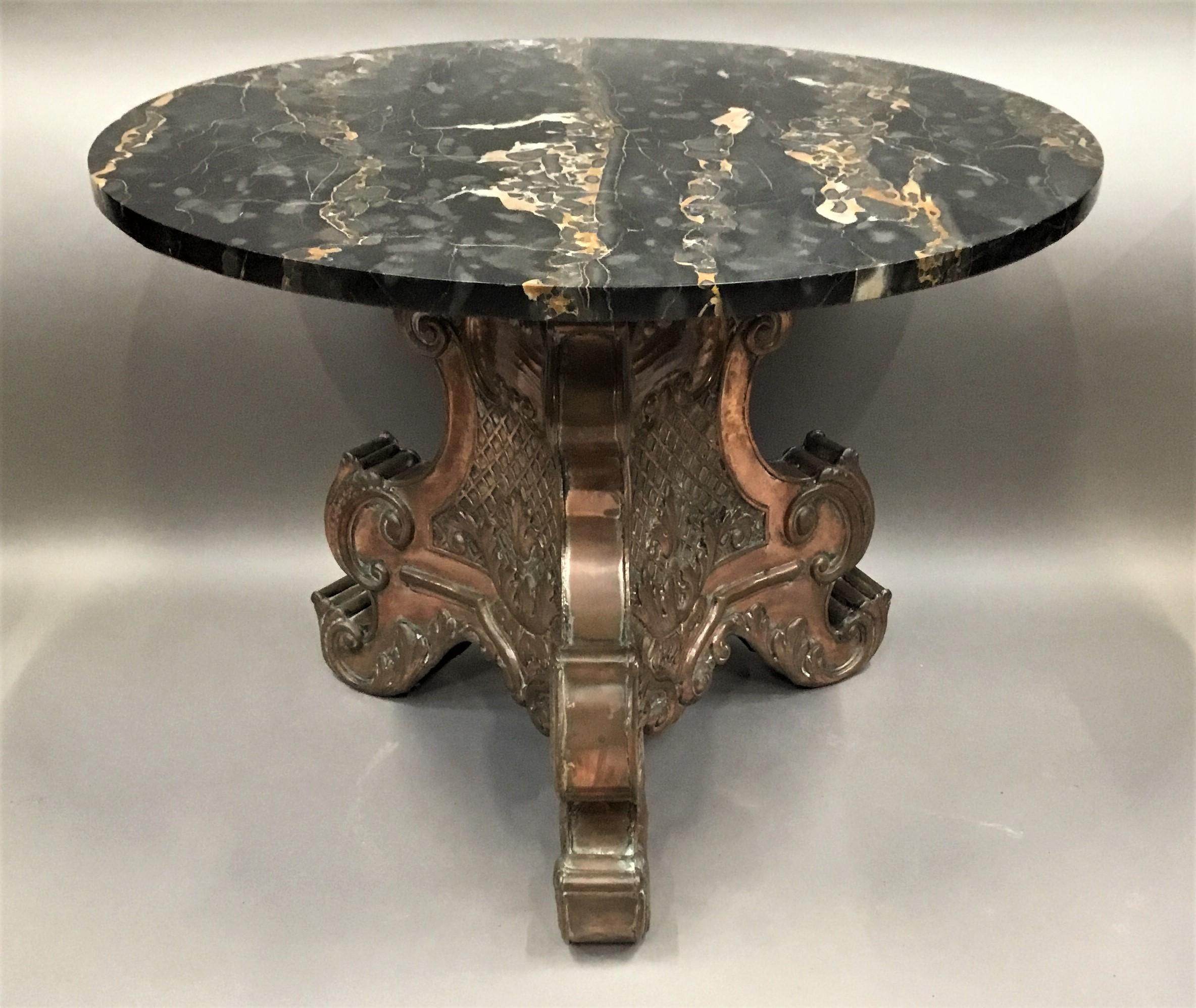 A striking Italian, copper and marble, low centre table / coffee table; B Battioli, Varese 1932; the circular Portio marble top raised on the unusual copper trianglar shaped base with concave sides with repousse decoration with exaggerated scrolled