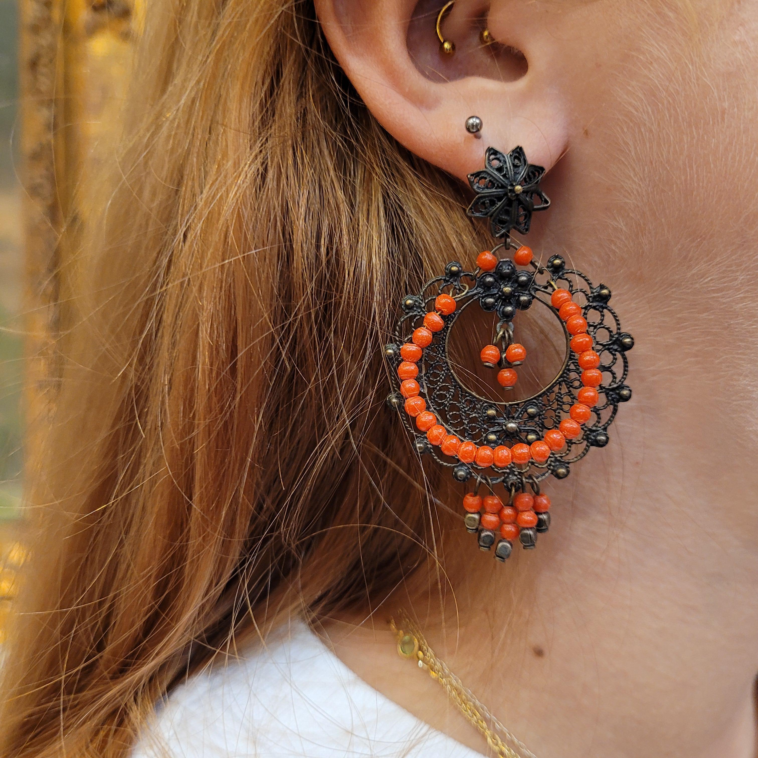 Beautiful  drop earrings in bronze filigree and coral pearls, with a circular profile and a great tribal influence, these earrings become an exclusive and timeless piece, suitable with any outfit and on any occasion.
Italian jewelry with a goldsmith
