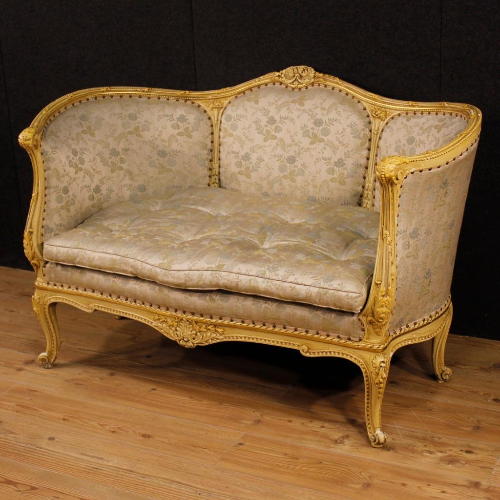 Italian corbeille sofa from 20th century. Furniture in richly carved and lacquered wood of great quality. Sofa of excellent proportion ideal to fit in a bedroom or living room. Furniture upholstered in fabric with floral decorations with some small