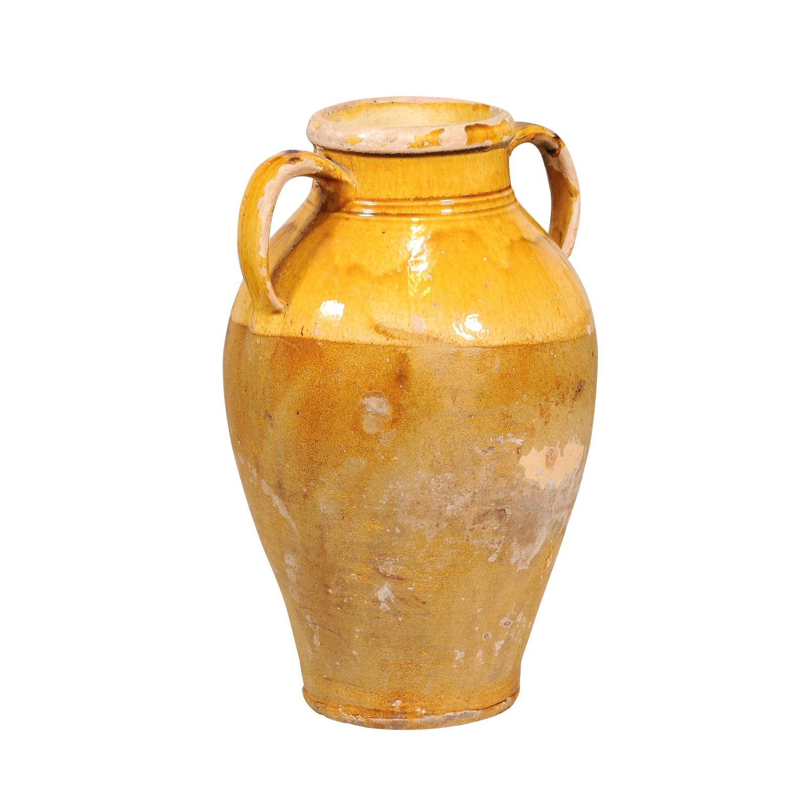 An Italian pottery pot from the 20th century with yellow glaze, two large handles and tapering lines. This Italian pottery pot from the 20th century is a vibrant blend of functional design and rustic charm. With its sun-kissed yellow glaze adorning