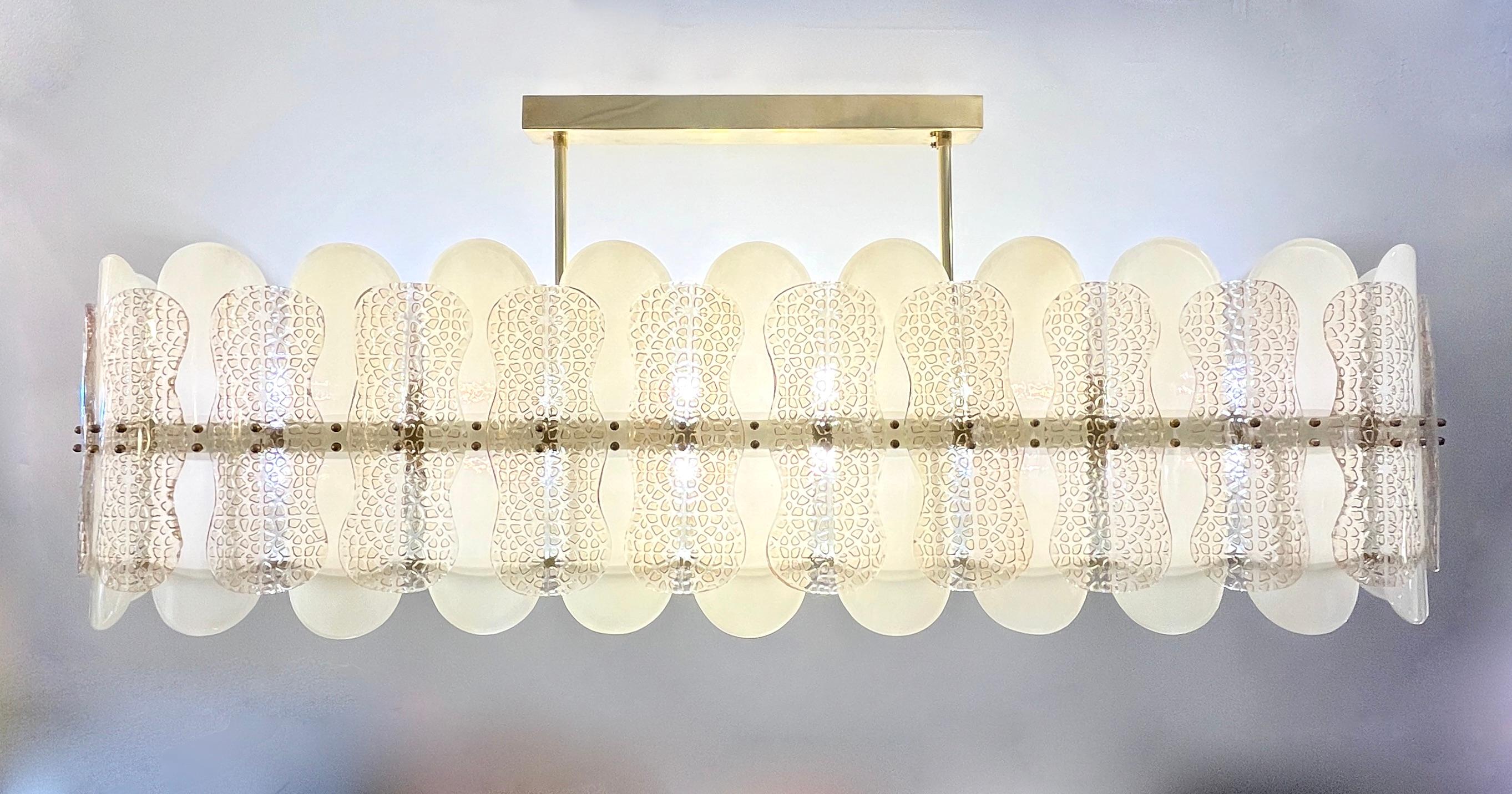 Esta lujosa lámpara de araña moderna, personalizable, presenta un sofisticado diseño ovalado fabricado totalmente a mano en Italia. Compuesta de sofisticados elementos geométricos ovales curvados de cristal de Murano en color crema perla marfil, y