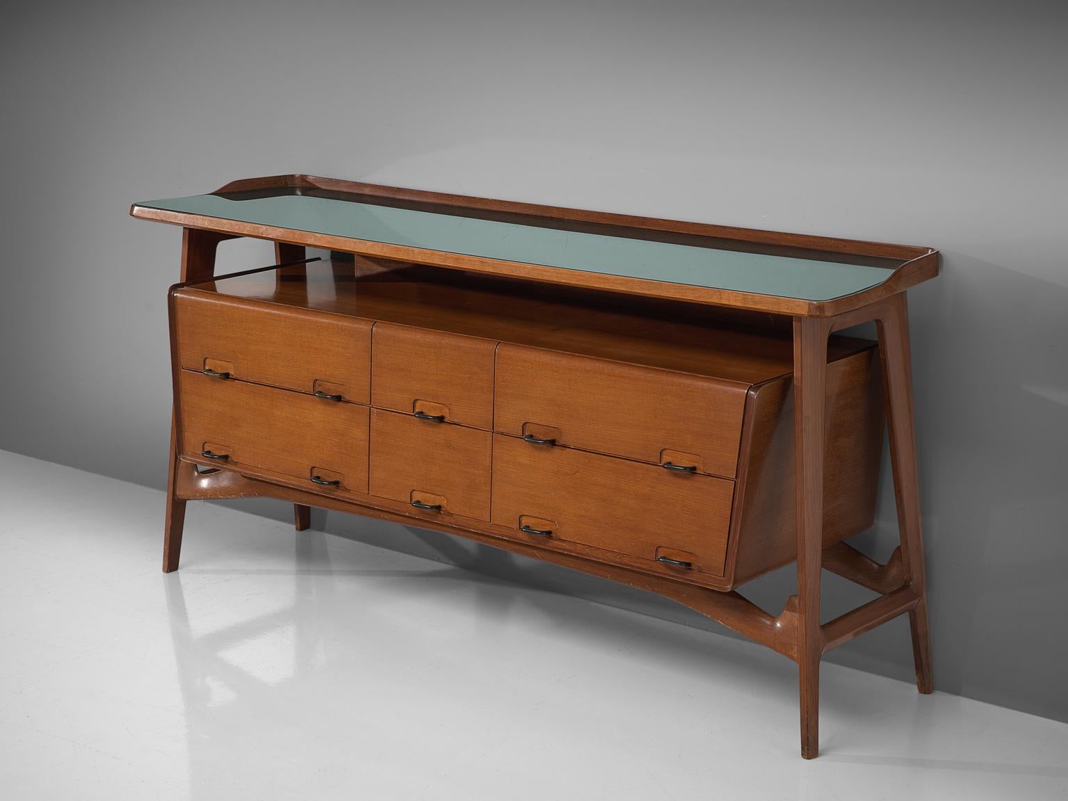 Credenza, fruitwood, glass, brass, Italy, 1950s

This sideboard is both refined and elegant in every way. The glass top stretches slightly over the outer edges of the solid, precisely crafted legs. This piece is playful and airy. The biomorphic