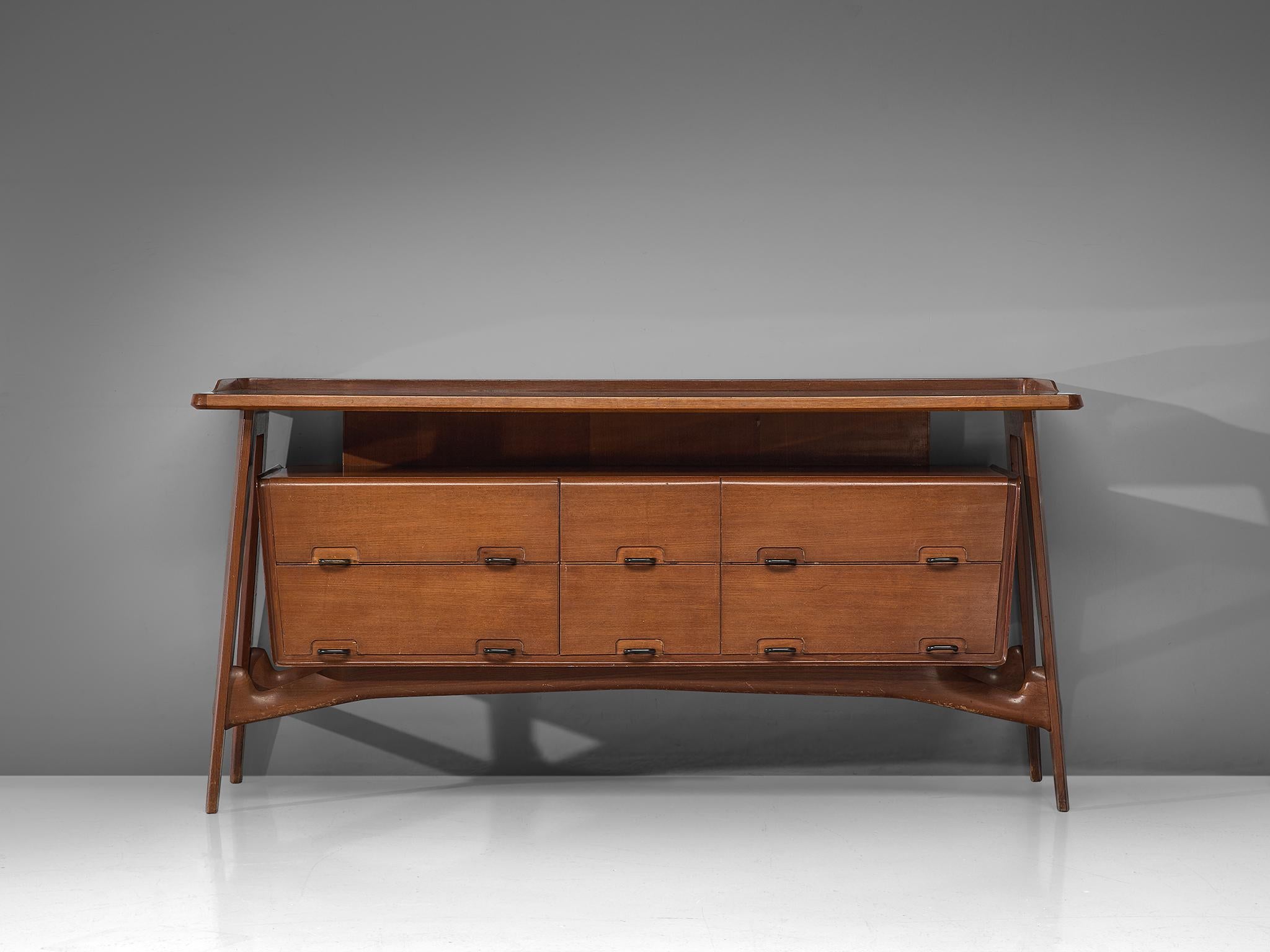 Credenza, fruitwood, glass, brass, Italy, 1950s

This sideboard is both refined and elegant in every way. The glass top stretches slightly over the outer edges of the solid, precisely crafted legs. This piece is playful and airy. The biomorphic