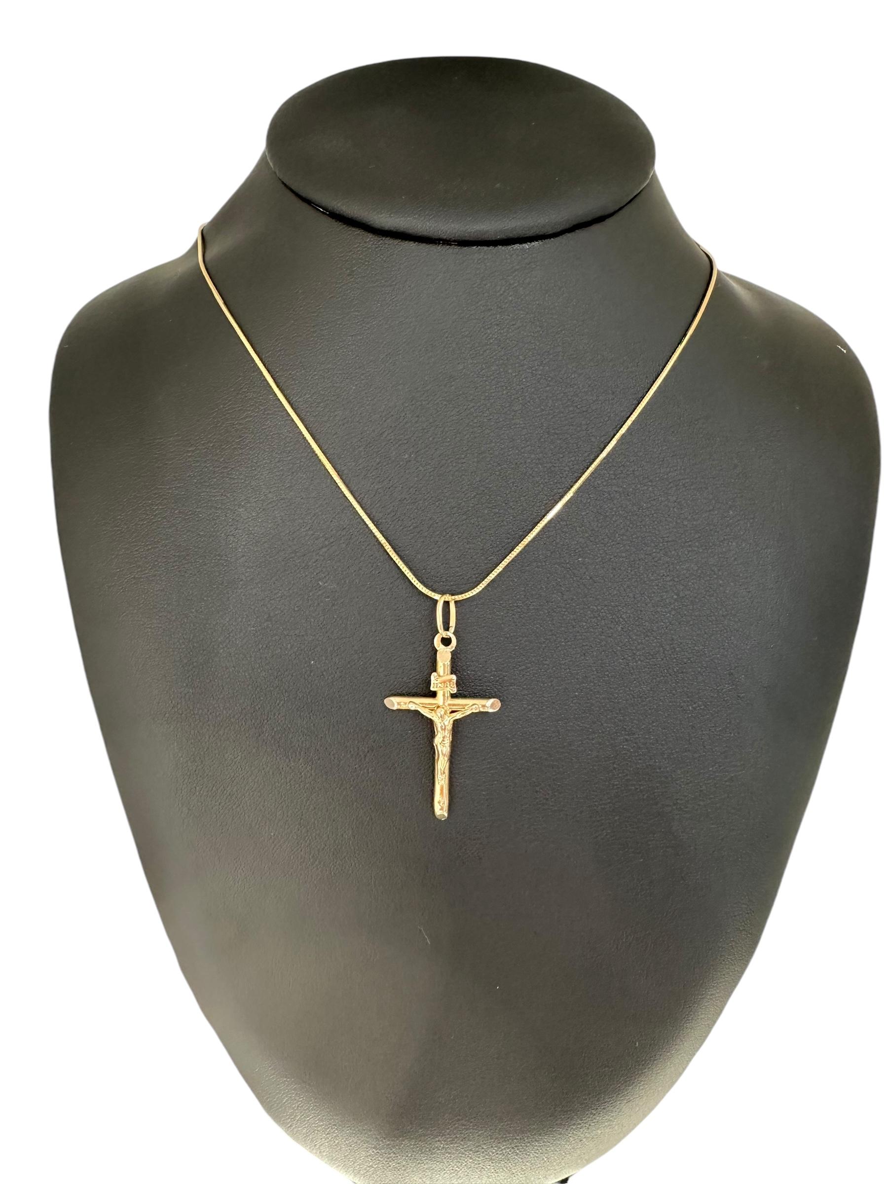 Ce pendentif en forme de crucifix italien est une pièce magnifique et significative réalisée en or jaune 18 carats. Le pendentif présente un crucifix finement détaillé avec une inscription traditionnelle 