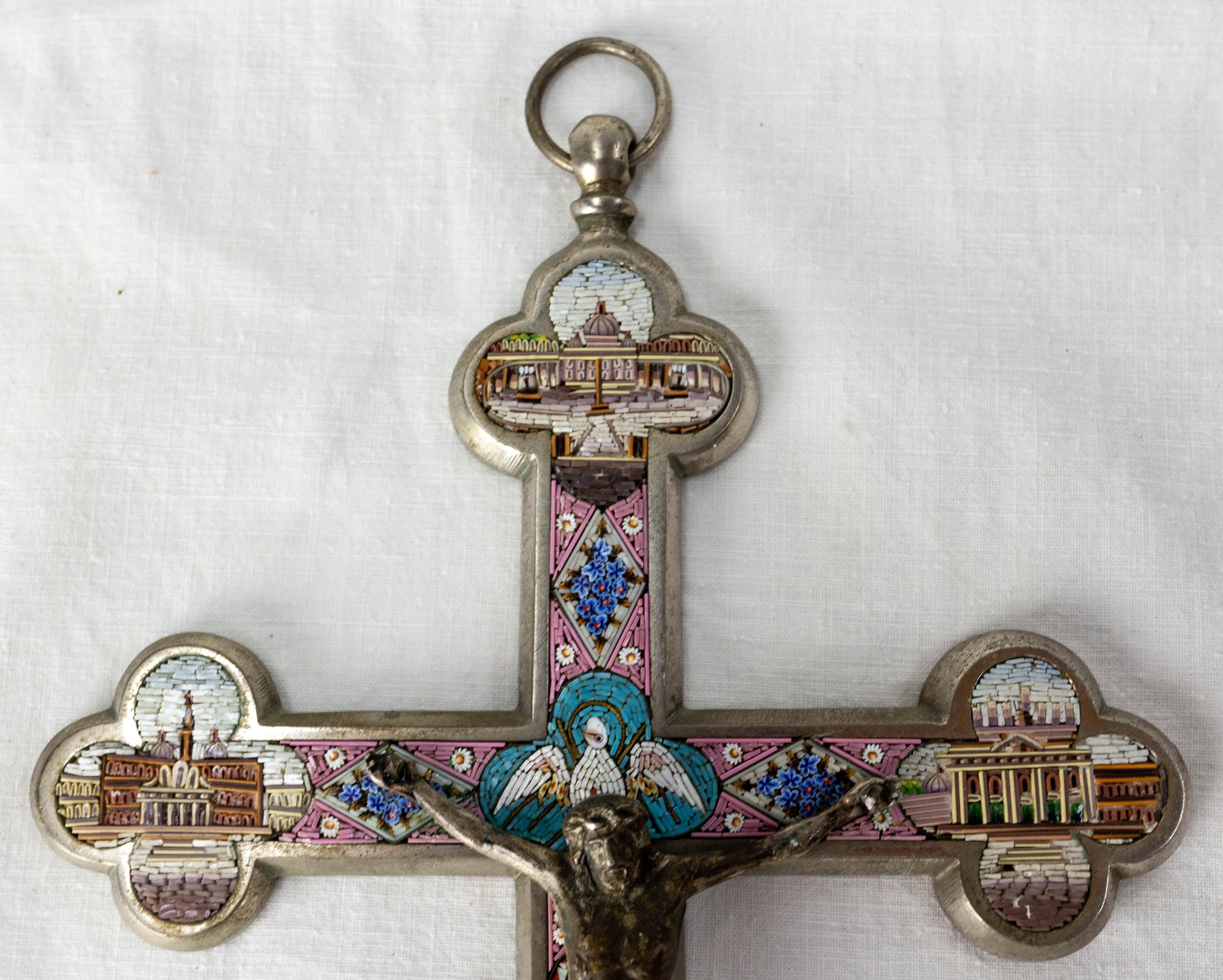 Crucifix adorned with a micro mosaic of colored glass 
Chromed brass
Around the Christ on the cross, you can see monuments of Vatican and of Rome ( Saint Peter's Basilica, Pantheon, column of Roman Forum ...). 
An angel, bouquets of flowers are