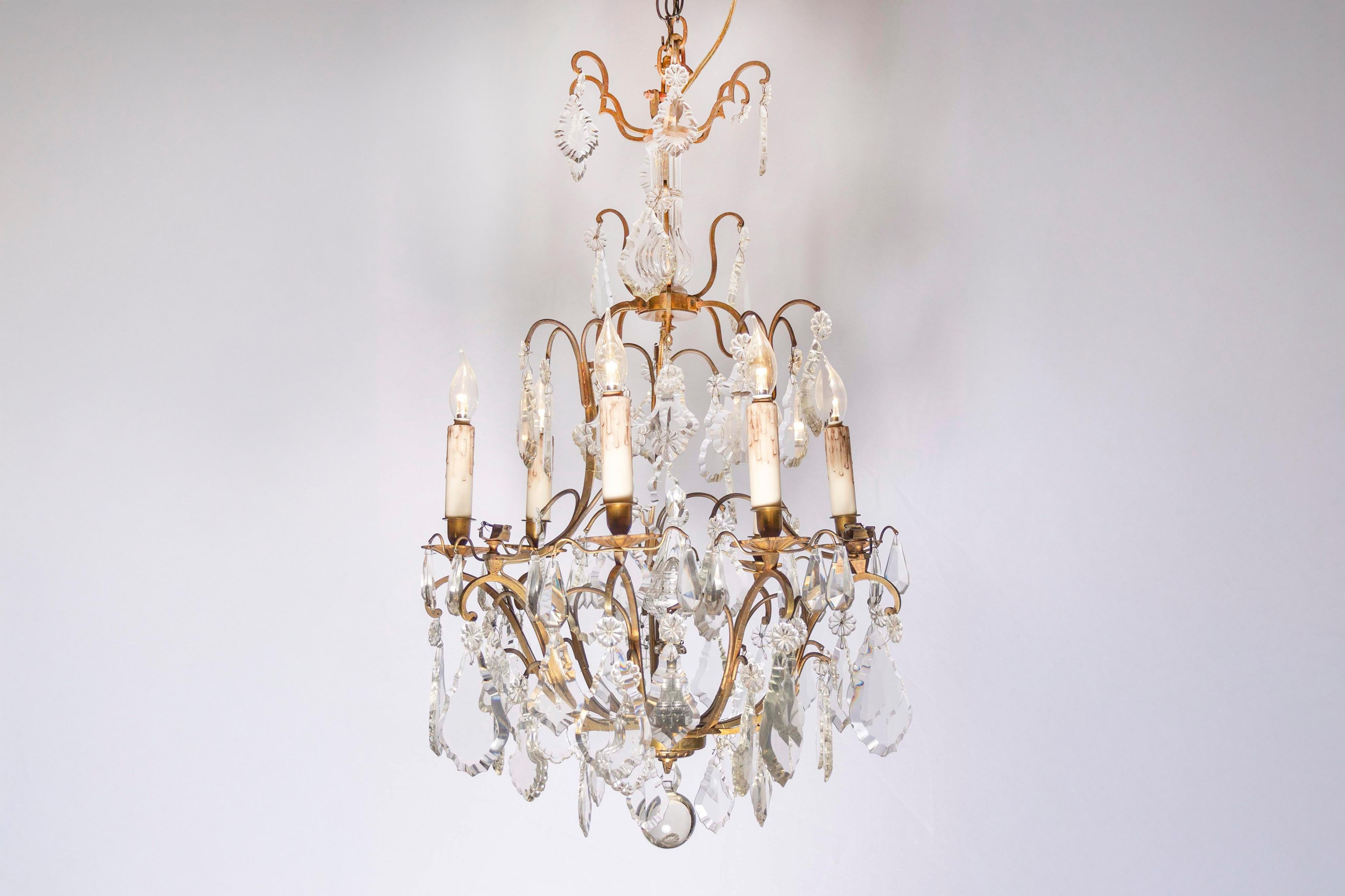 Lustre italien en cristal et bronze à six lumières du milieu du XIXe siècle, avec obélisque central, pendeloques et rosettes. Né en Italie au cours du troisième quart du XIXe siècle, cet élégant lustre présente une armature en bronze supportant une