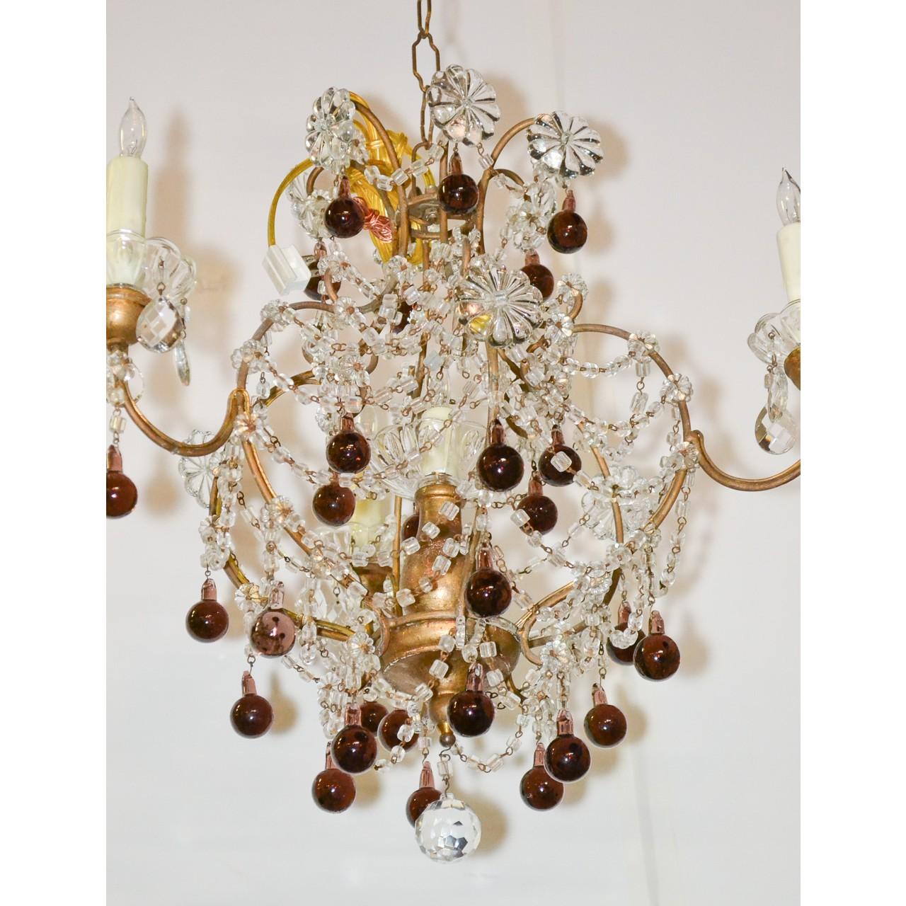 Superb small-scale Italian cut crystal and gilt-tole chandelier featuring cascades of bead crystals, large crystal flower heads, and accented overall with dark amber-colored glass orbs. The base with a faceted crystal sphere,

circa 1920.