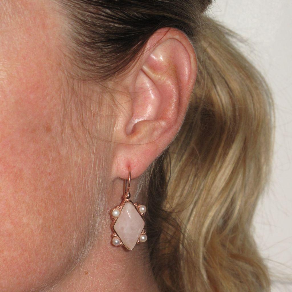 For pierced ears.
Earrings in silver and rose gold.
Lever- back shape, they support a pale pink crystal cut in a lozenge shape and set on these 4 sides with white glass pearls. The clasp is a swan neck with safety hook.
Height: 3.6 cm, width at