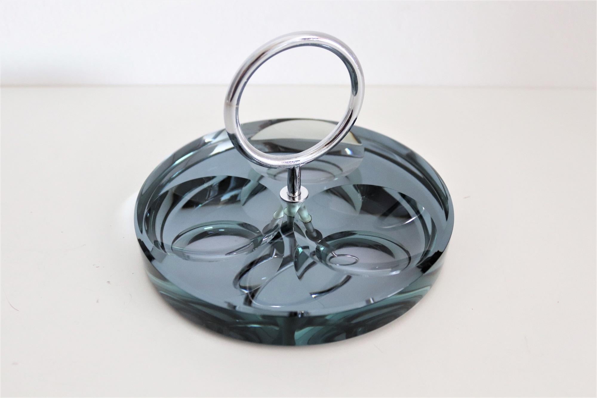 Magnificent ashtray made of gorgeous thick mirrored crystal glass in beautiful grey-green color with three big round indentations on the glass.
With chrome holder fixed within the glass.
Made from Fontana Arte in the 1960s.
Excellent