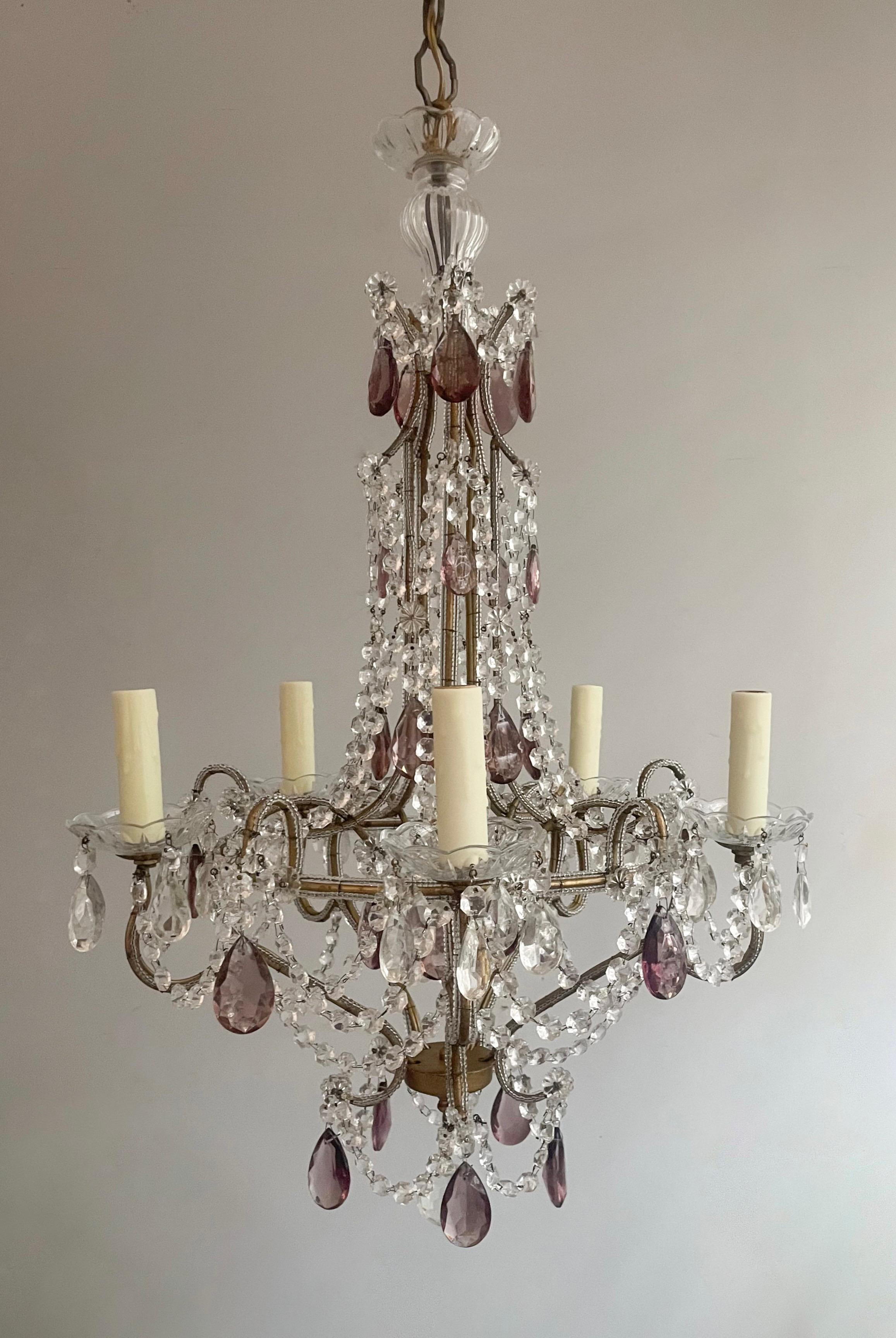 Beautiful, Italian 1960s gilt-iron and crystal beaded chandelier with amethyst drops.

The chandelier features a shapely scrolled-iron frame decorated with an abundance of glass beads and accented with amethyst glass faceted prisms. 

The chandelier