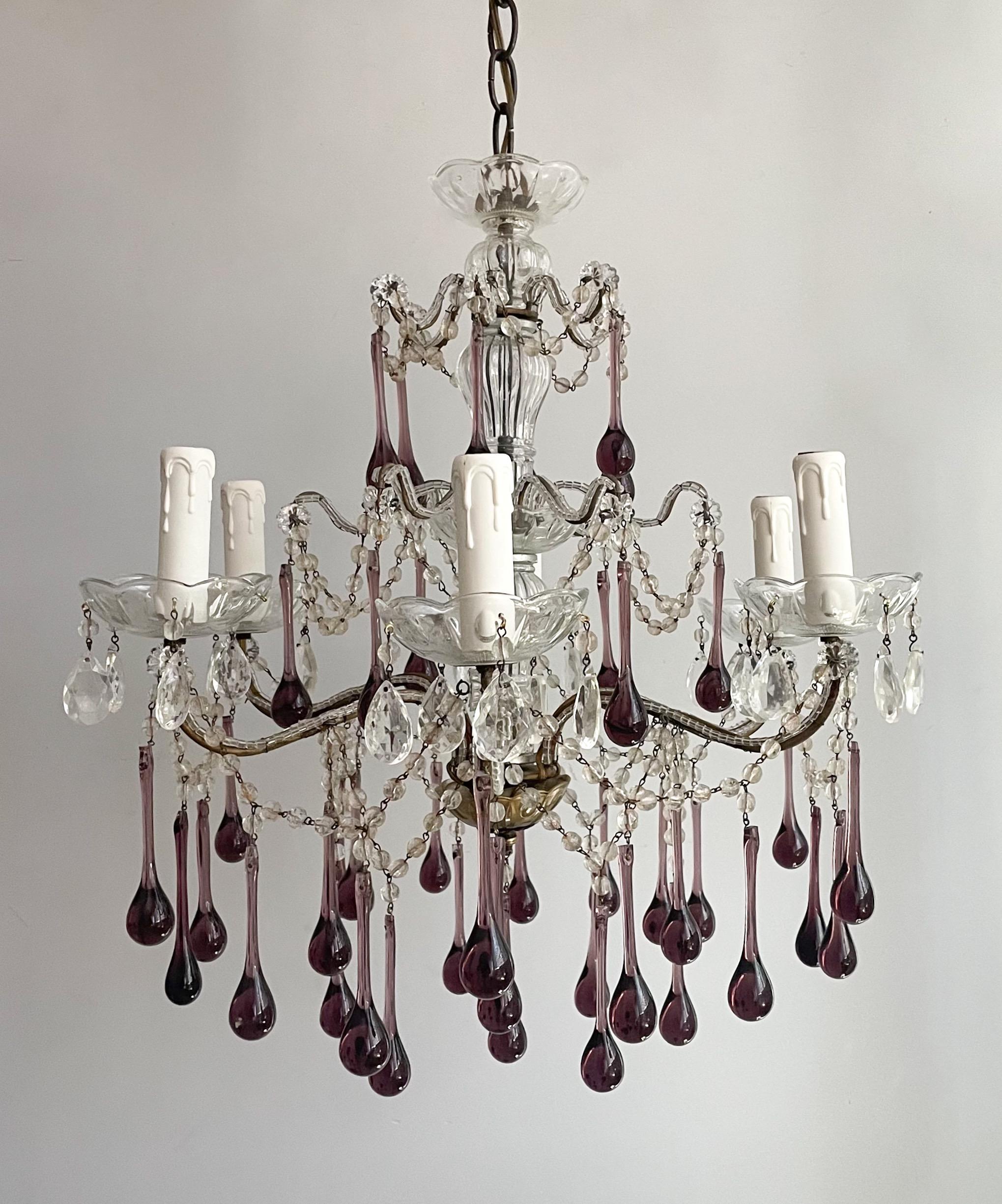 Beautiful, Italian 1960s crystal beaded chandelier with Murano glass drops.

The chandelier features a glass beaded iron frame with a fluted crystal column at its center and long Murano glass ball drops in a rich amethyst hue.

The chandelier is