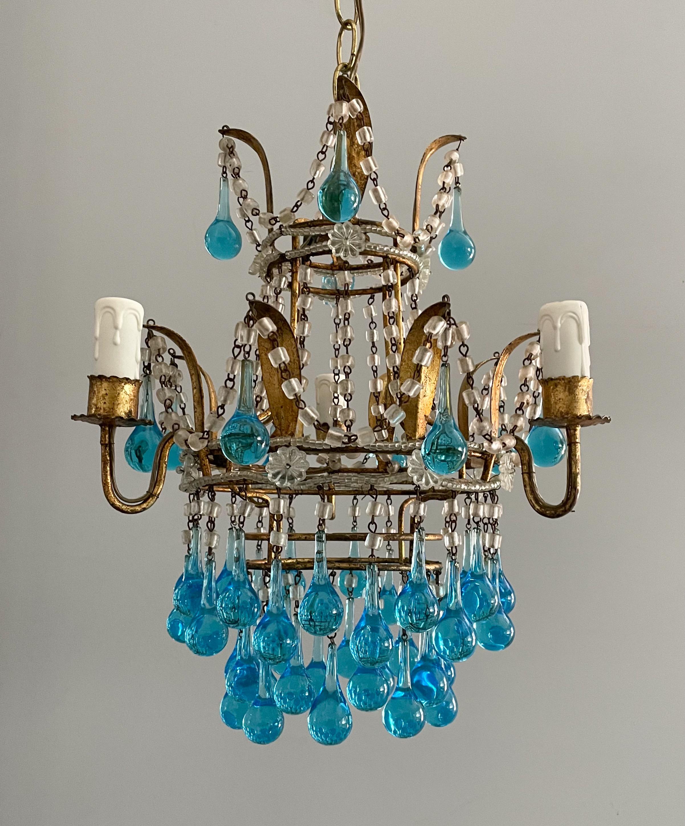 Gorgeous, 1940s Italian gilt-iron and crystal beaded chandelier with Murano glass drops.

The chandelier features a gilded iron frame in the shape of a leafy crown decorated with macaroni glass beads and blue Murano glass ball drops.

The