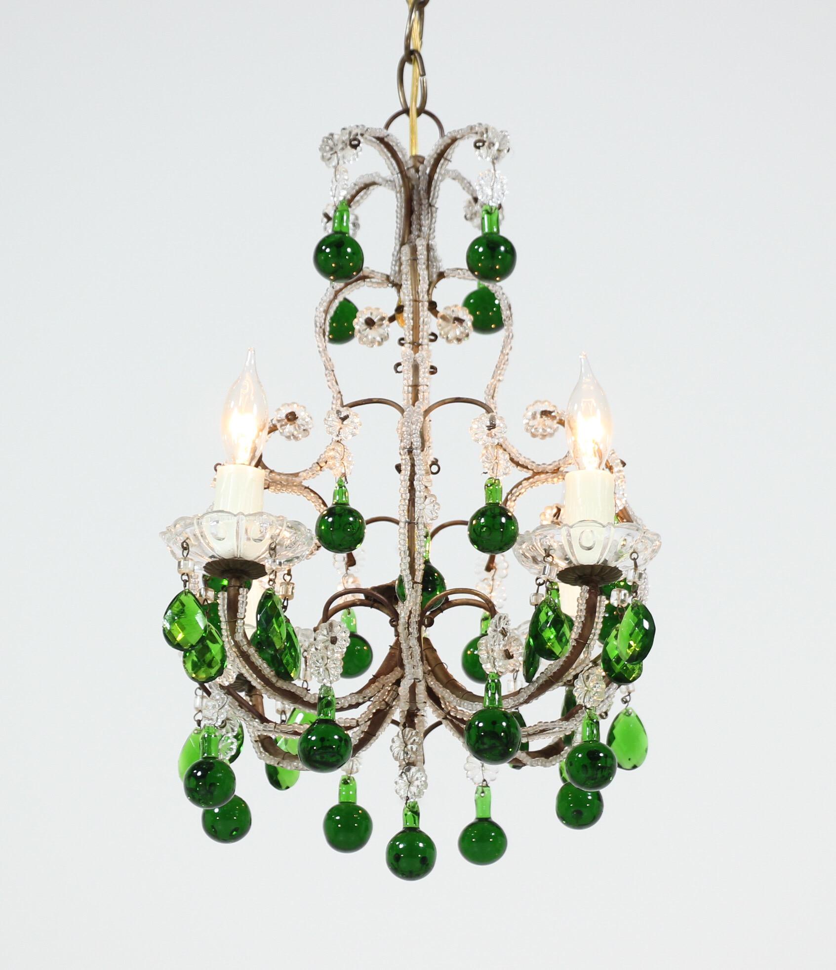 Very pretty, 1950s Italian crystal beaded chandelier with green Murano drops.

This petite-scale chandelier features a crystal beaded gilt-iron frame which has been decorated with emerald green Murano glass drops and prisms. New bee wax candle