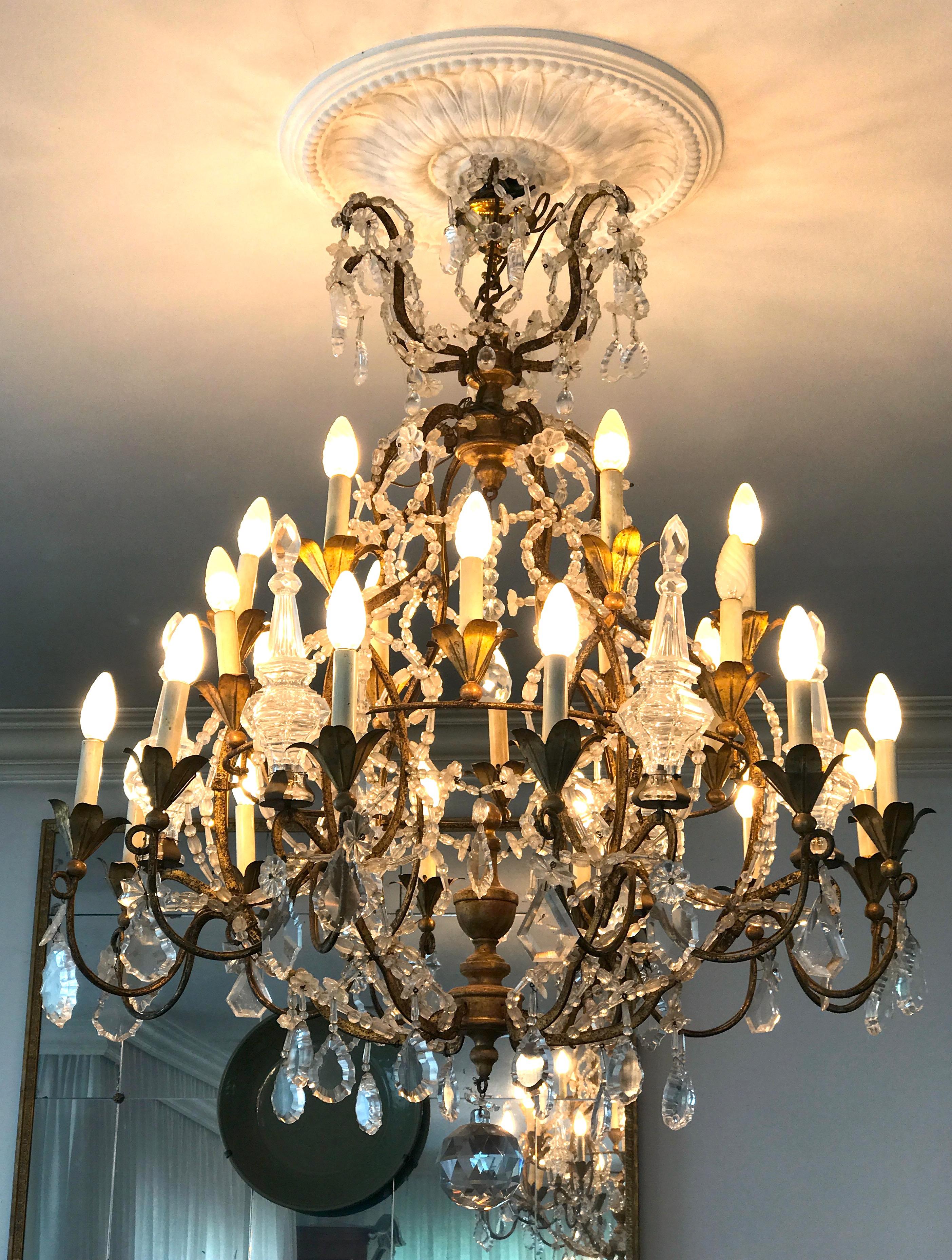 Charming 18th century Nord - Italian chandelier with elaborately scrolled gilt metal arms draped with cascades of cut crystal beads. Accented overall with superb crystal drops. Beautiful foliate motif candle cups , centered by a giltwood base.