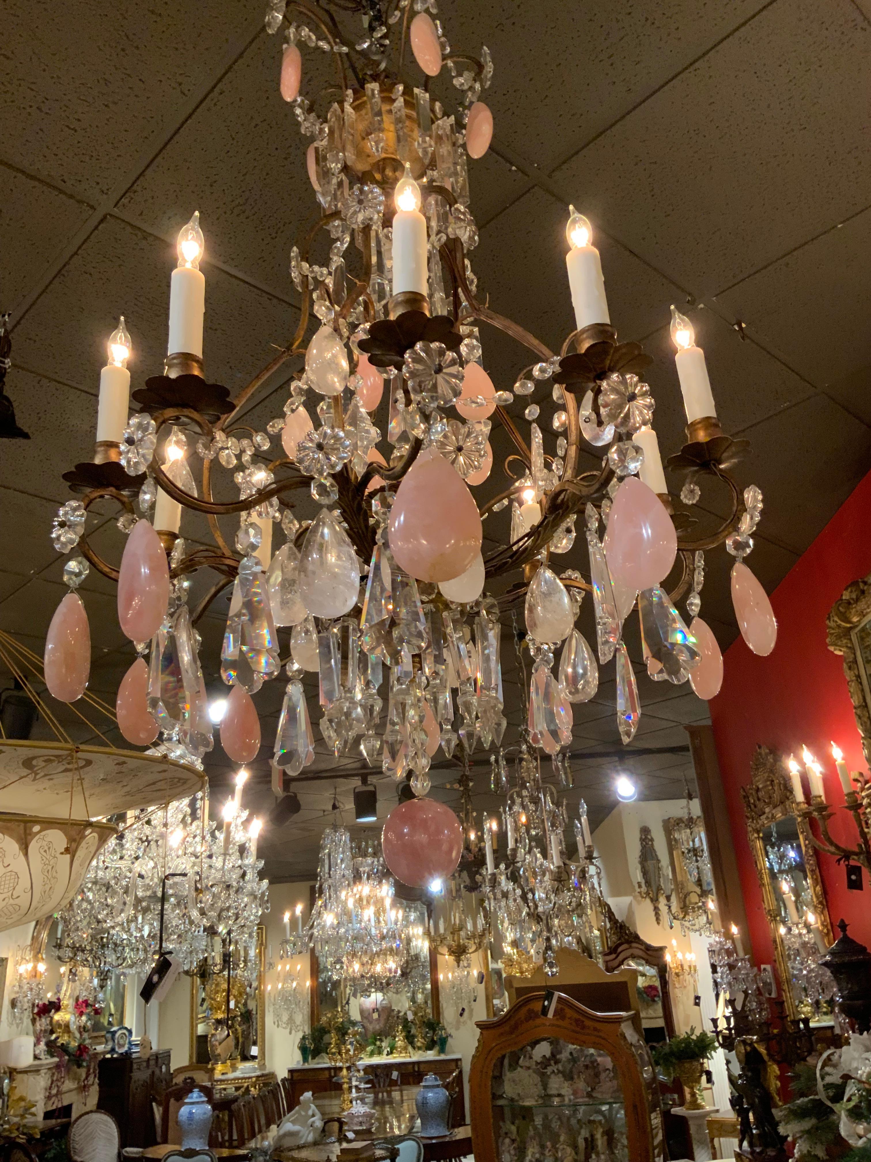 Lo squisito mix di cristallo chiaro, cristallo di rocca e quarzo rosa 
Il cristallo rende questo lampadario speciale. Ha uno scorrimento 
Le braccia sono in bronzo e da esse fuoriescono dieci luci.
Sul fondo viene utilizzata una grande sfera di