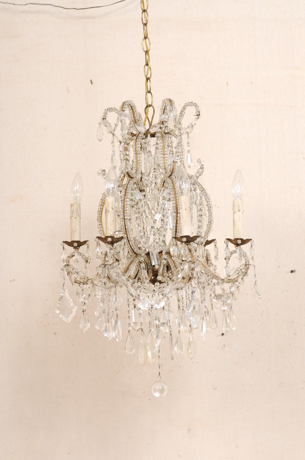 Lampadario italiano di piccole dimensioni a sei luci in cristallo con armatura in ferro, della metà del XX secolo. Questo lampadario vintage proveniente dall'Italia presenta una bella varietà di cristalli sagomati e perle di vetro italiane che