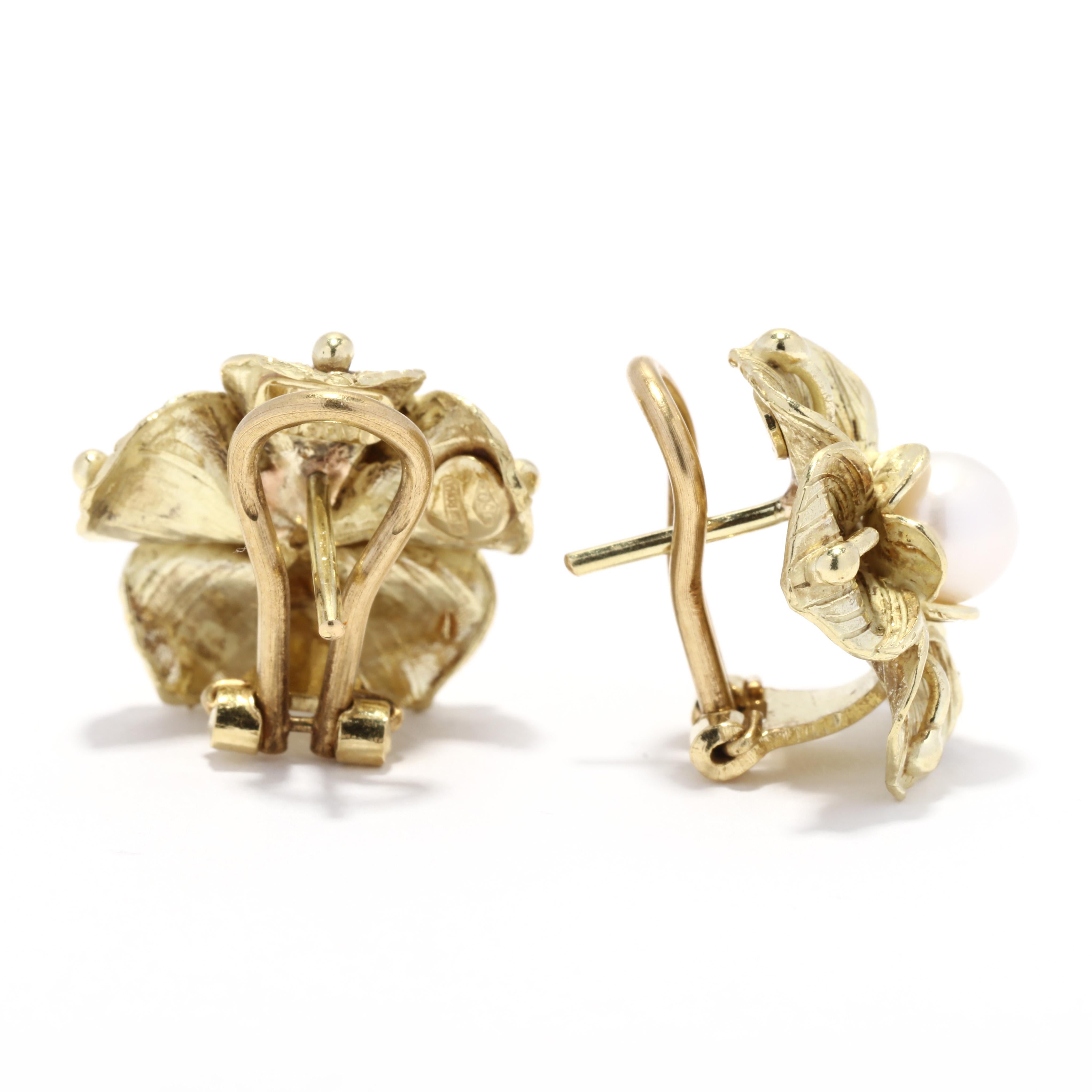 A pair of vintage 18 karat yellow gold cultured pearl flower earrings. These earrings feature three dimensional flower earrings with a matte finish, each with a 6mm white cultured pearl set in the center and with pierced omega backs.

Stones:
-