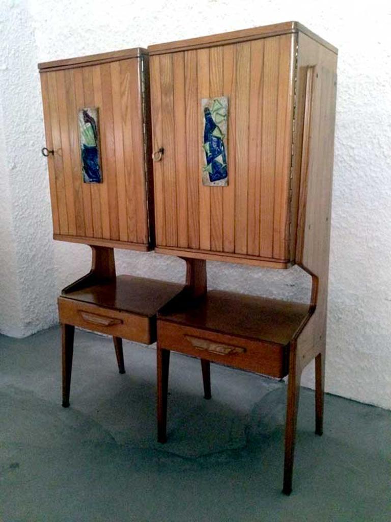 Italian cupboard attributed to Ico Parisi, produced in Italy in 1950s.
The two frontal openable panels are made with grooved blonde oakwood, on the frontal panels there are two beautiful Majolicas tiles hand painted.
There are also two surface in