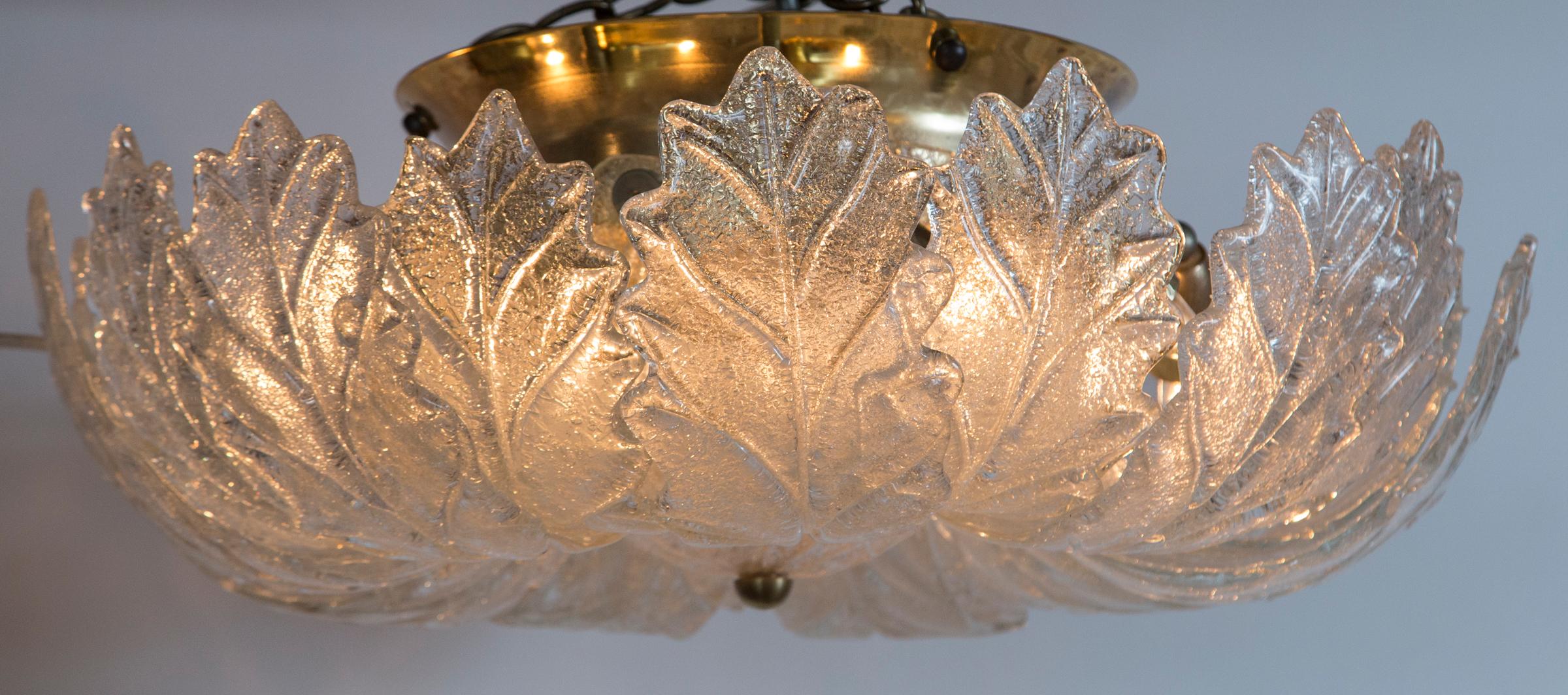 These Italian frosted clear glass fixtures illuminate with a warm and icy effect, composed of 18 curled leaves finishing with a center glass bowl and brass hardware, note wonderful size! Substantial light for a small size.
Illuminates with 9