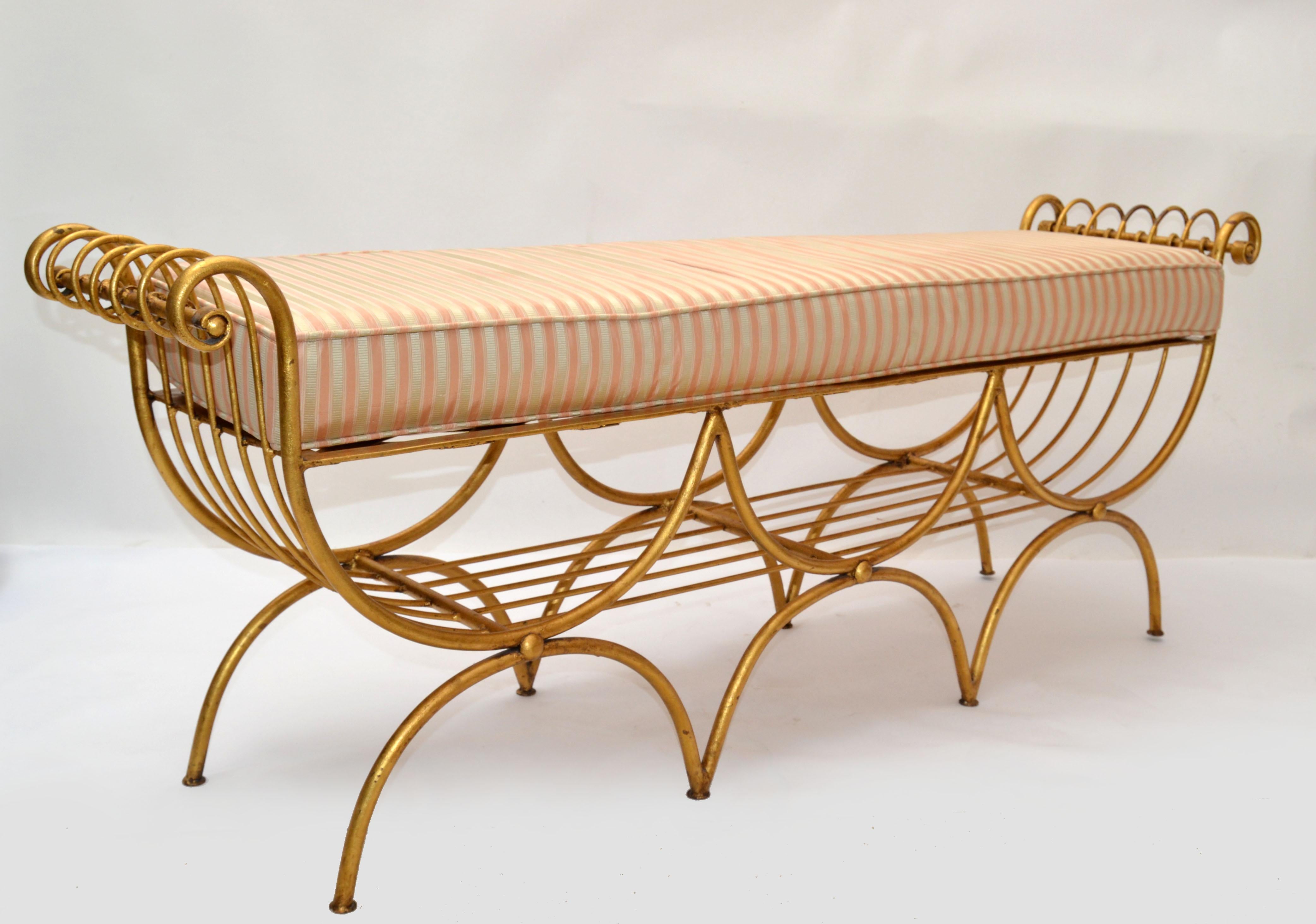 Beautiful Hollywood Regency gilt wrought iron and steel curule 3-seater Long Bench made in the late 1950, from Italy.
Semi circled tubular steel legs in gilt finish and cross woven seat area.
Comes with the original silk fabric seat cushion and is