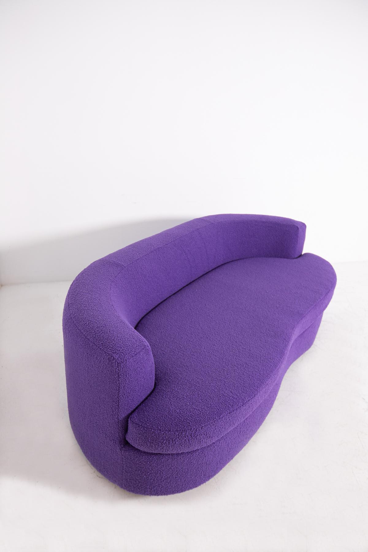 Elegant and modern Italian sofa from the 1960s. The semi-curved sofa has a curved shape. Its soft lines gently accompany the entire structure. The sofa has been reupholstered in soft purple bouclé fabric. Its feet are made of wood in a rectangular