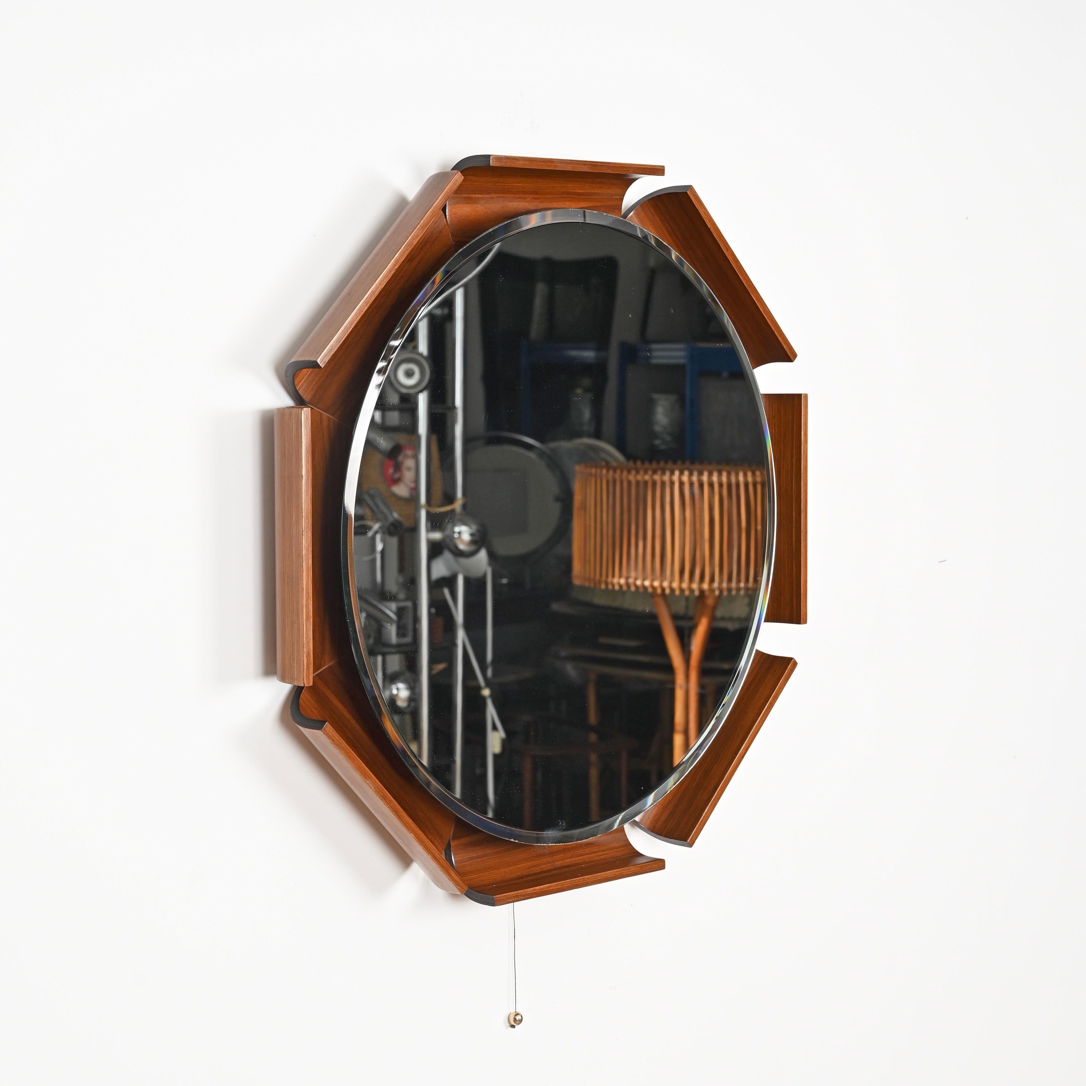 Spectacular and incredibly rare backlit mirror in curved teak beveled mirror designed by Ico Parisi and produced by ISA Bergamo in Italy in 1968.  

The outstanding quality of the wood used and the striking design make this mirror extremely
