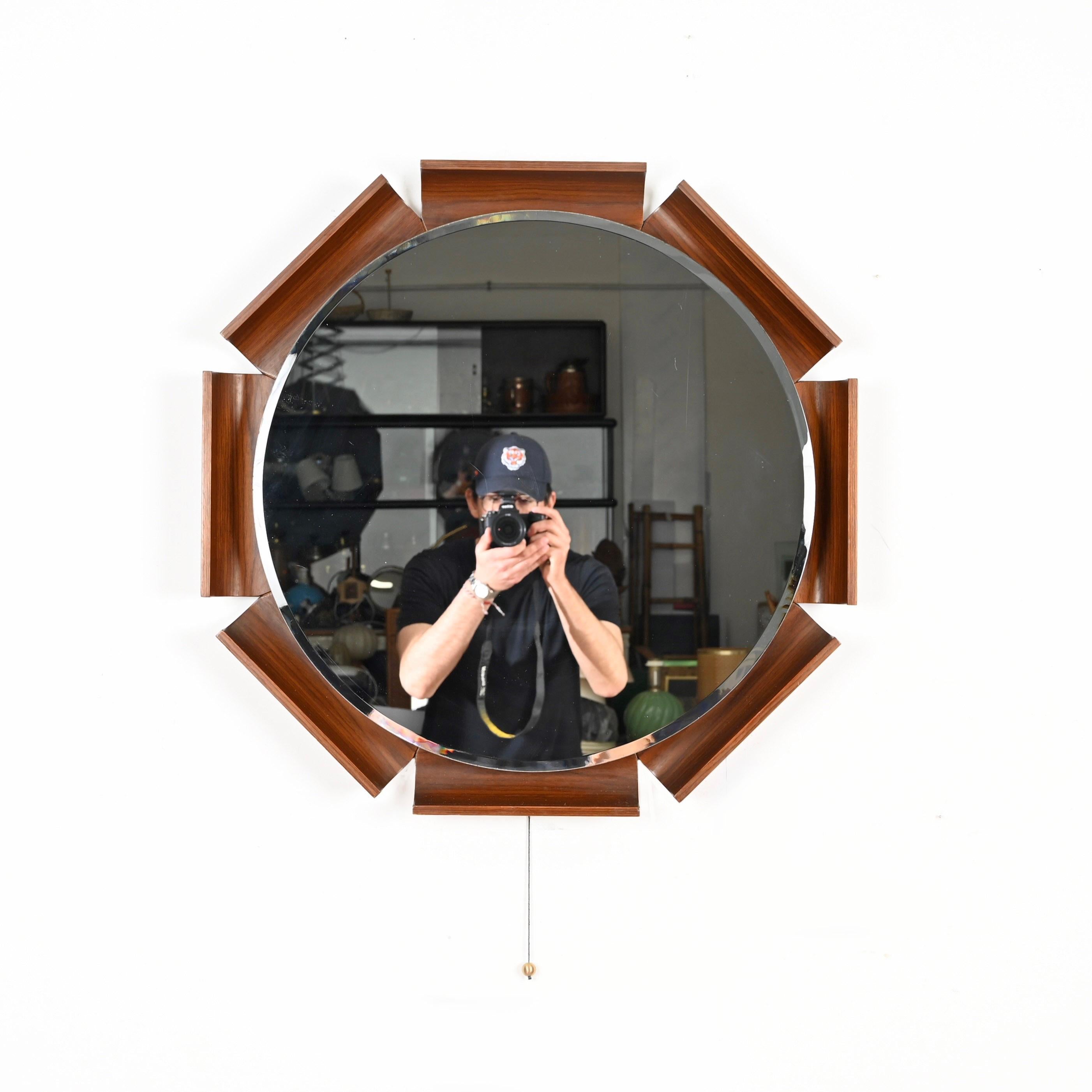 Spectacular and incredibly rare backlit mirror in curved teak beveled mirror designed by Ico Parisi and produced by ISA Bergamo in Italy in 1968.  

The outstanding quality of the wood used and the striking design make this mirror extremely
