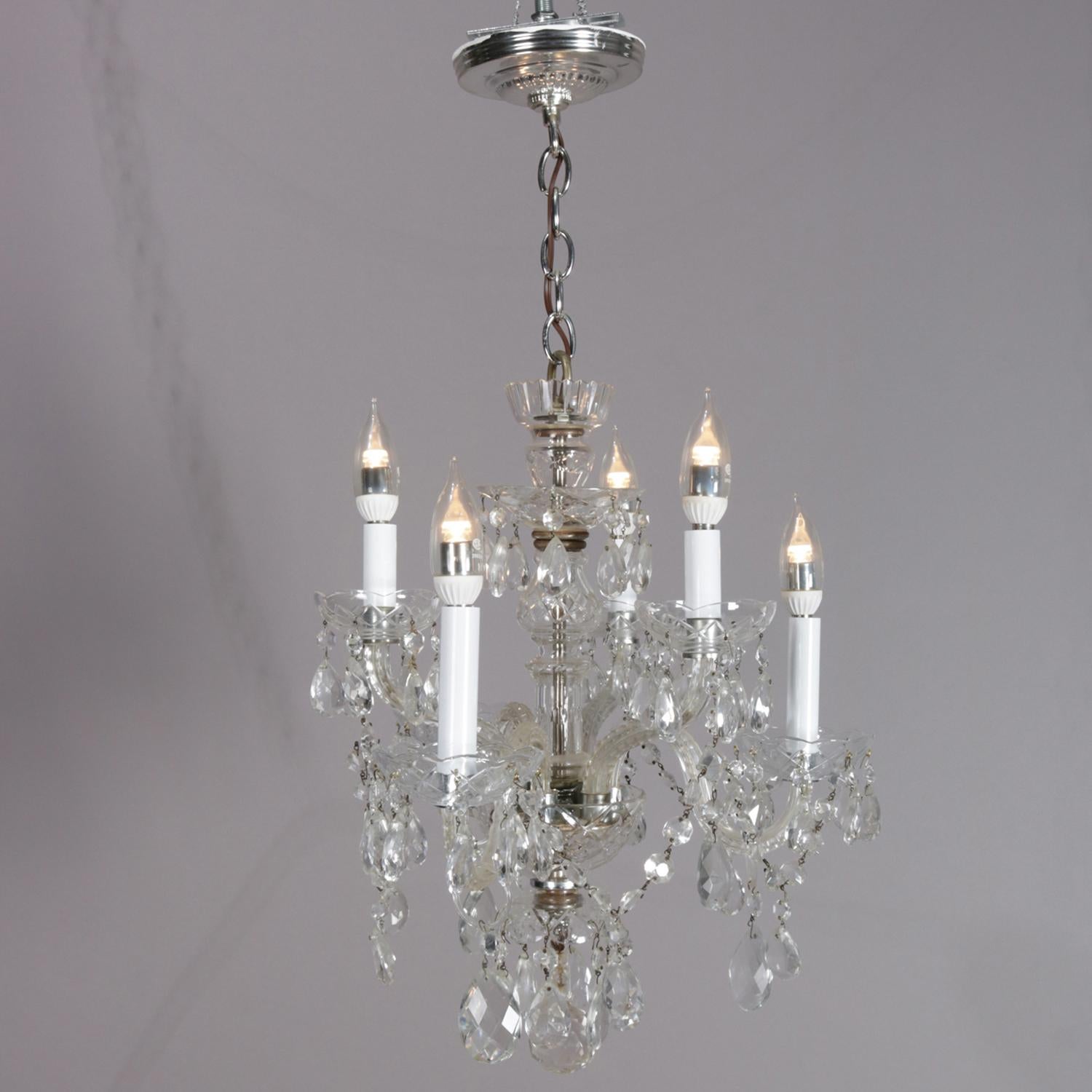 Italian petite chandelier features chrome frame with crystal body having six S-scroll glass arms terminating in candle lights, all-over highlighted with strung and hanging cut crystal prisms, professionally re-wired, circa 1940

Measures: 30