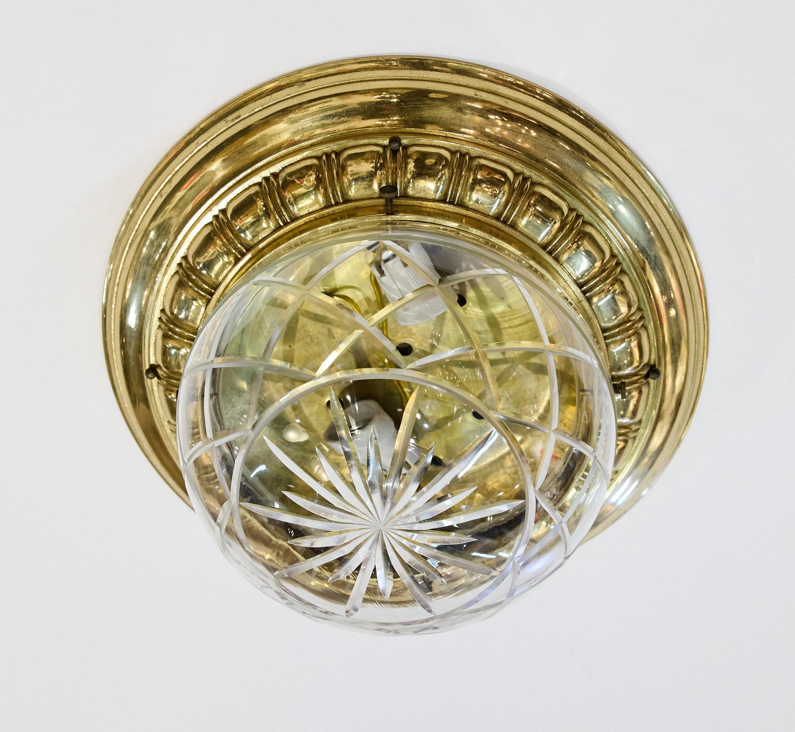 Early 20th Century fine quality Italian flush mount light fixture with a heavy decorative brass base that holds a round glass dome that is cut into a starburst in the center and surrounded by a cut-glass lattice pattern. The glass is very thick and