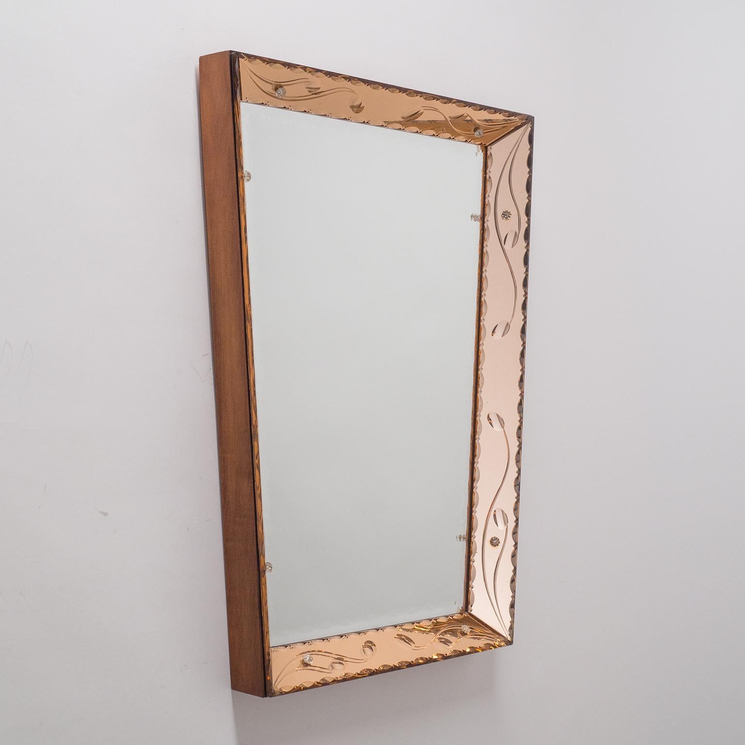 Beautiful Italian trapeze mirror with dual color mirrors. Inserted into a deep wooden frame are sheets of rosé-colored as well as a clear mirror. Each of these are intricately beveled, scalopped and cut with floral motifs. Width at the bottom is