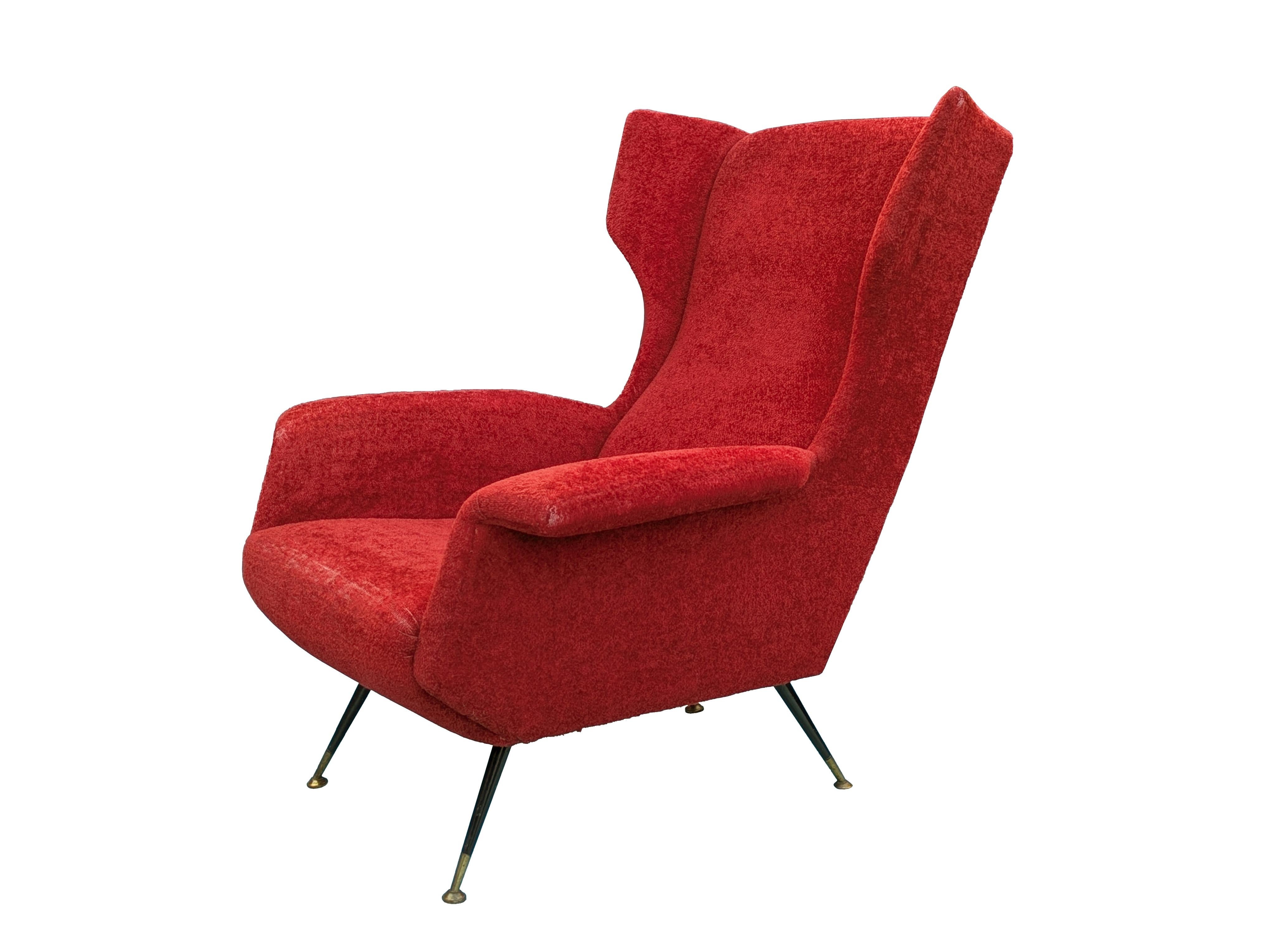 Sillón moderno de mediados de siglo de terciopelo rojo oscuro, metal negro y patas de latón. 
A pesar de su volumen, la silla tiene un diseño ligero y elegante gracias al delgado perfil de los reposabrazos y reposacabezas curvados y a los finos pies