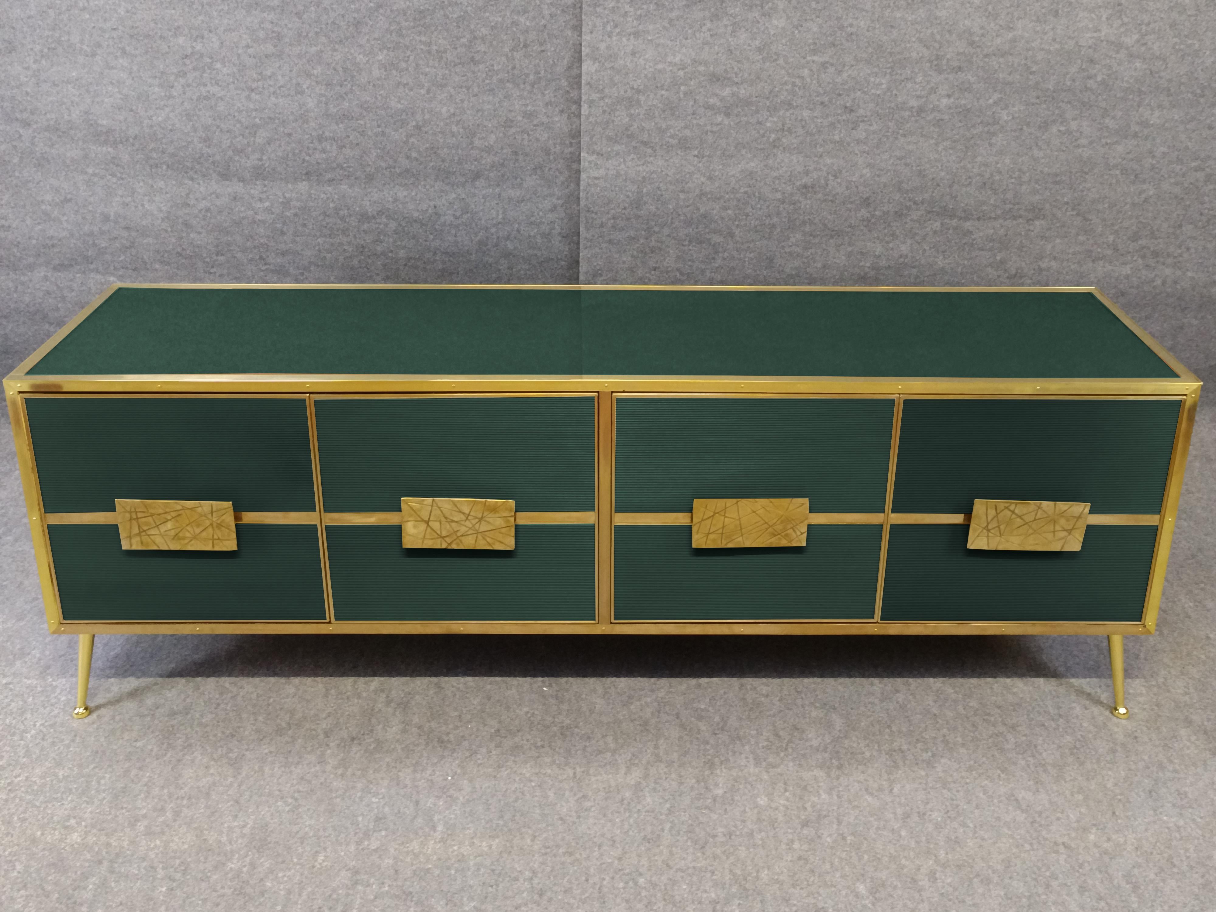 This exquisite dark green Italian buffet sideboard is a masterpiece of craftsmanship, blending Mid-Century Modern style with luxurious materials. 

The highlight are the four doors embellished with Murano ‘Grisinato’ glass, which create a