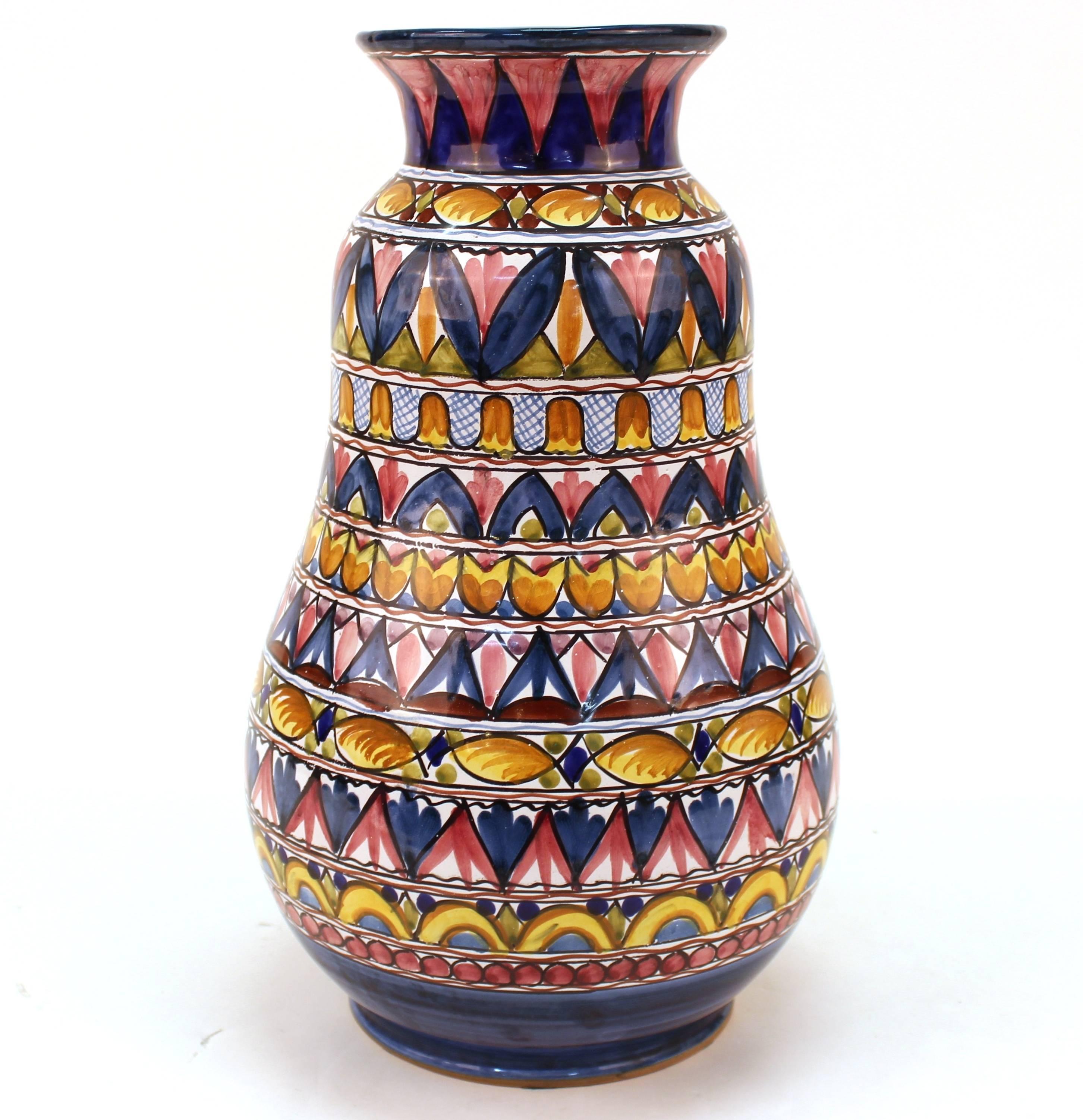 An Italian earthenware pottery vase with rows of colorful geometric designs, signed on the bottom 'De Marinis Vietri'. The piece is in great vintage condition.