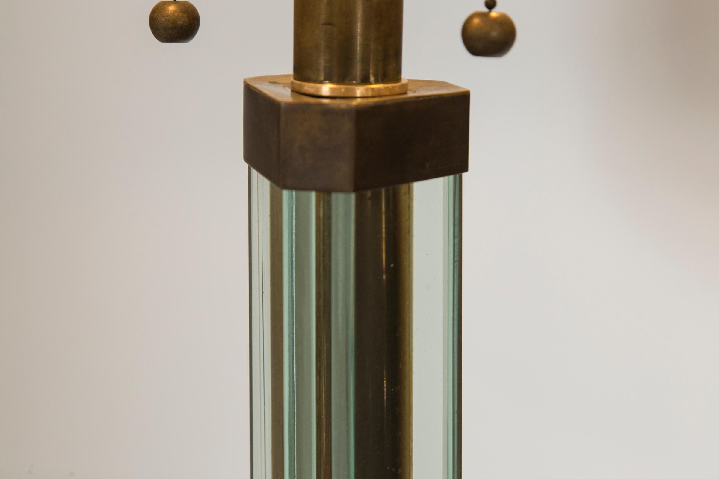 A lovely standing lamp with triangular shaped glass center shaft supported by brass fittings finishing on a hexagonal shaped glass base. The base is supllied with its original brass sfittings which serve as feet that can calibrate for level