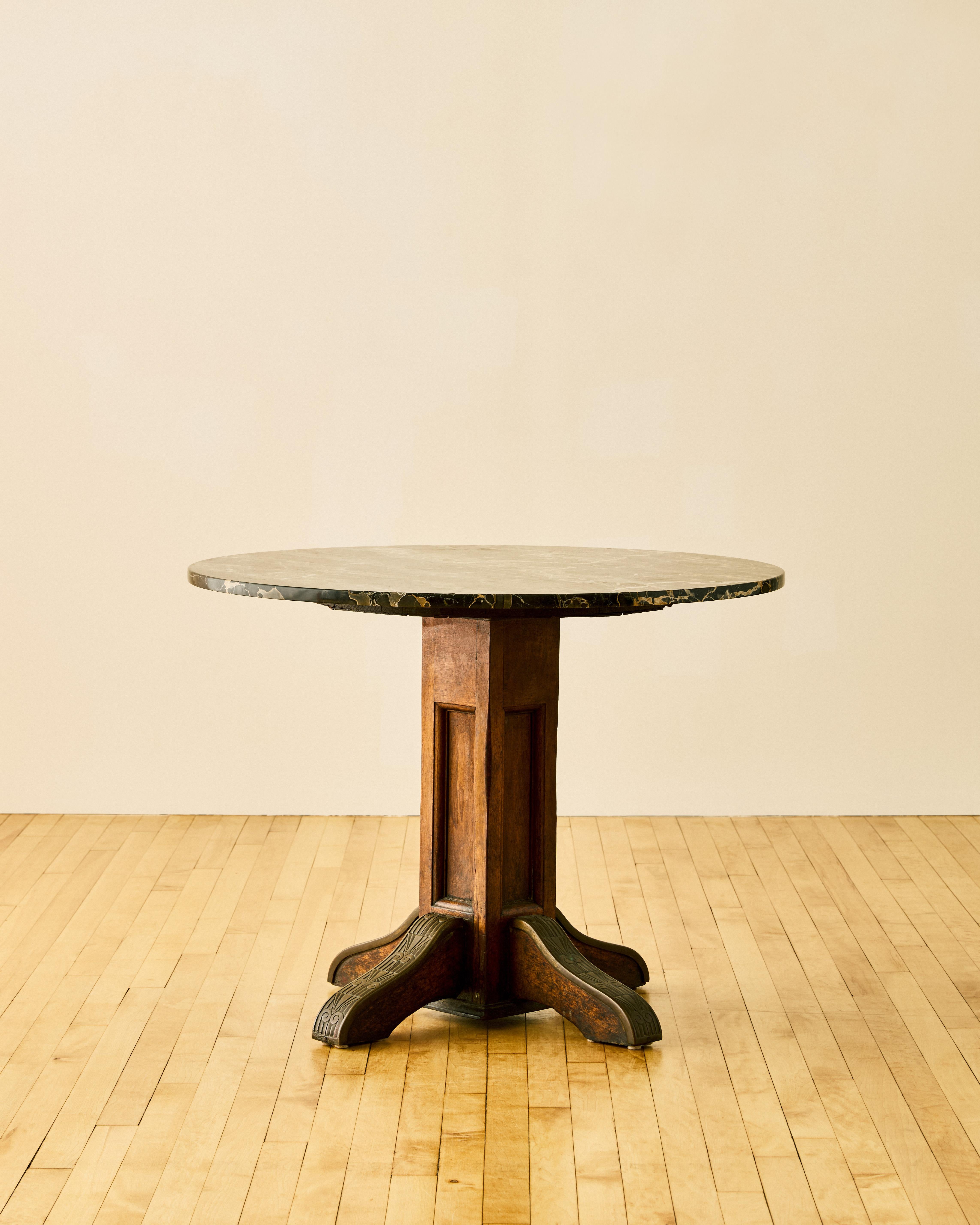 Italian Deco oak and black marble center table with four carved scroll legs.