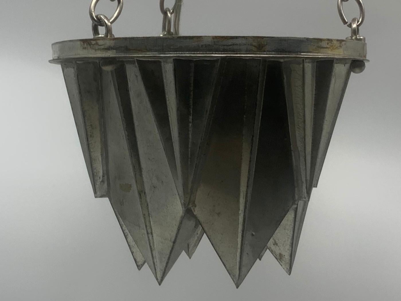 Italian deco pendant. Unique vintage 1930s angular tin cake mold pendant suspended from lid canopy with single newly wired Edison socket. Italy, circa 1930 
Dimensions: 8” diameter x 21