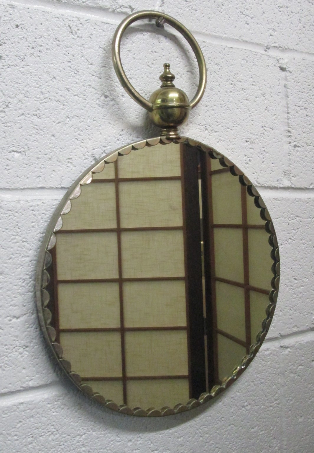 Miroir décoratif italien en laiton. Le miroir est doté d'un anneau en haut pour le suspendre.