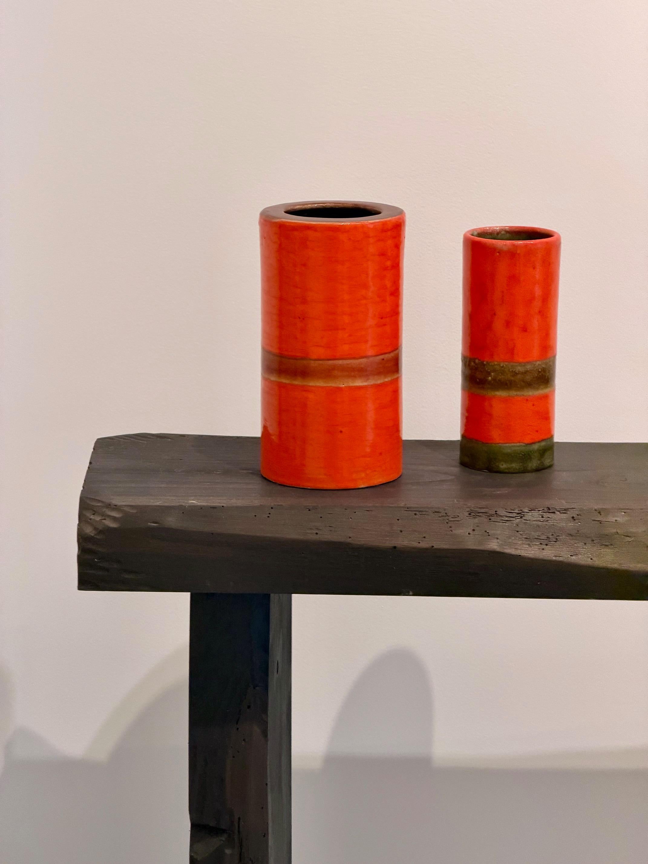 Paire de vases cylindriques de Bruno Gambone 
Émail orange foncé et brun
Mesures : H 20 cm x D&H 11 cm et H 17 cm x D&H 7 cm
Signé Gambone Italy à la base.

