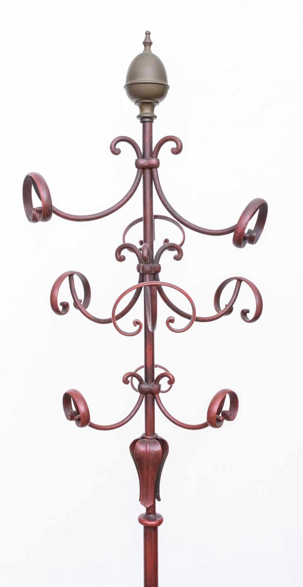 1940s Italian metal coat rack painted a deep red with a brass finial at the top. Coat rack is attributed to Fornasetti.


